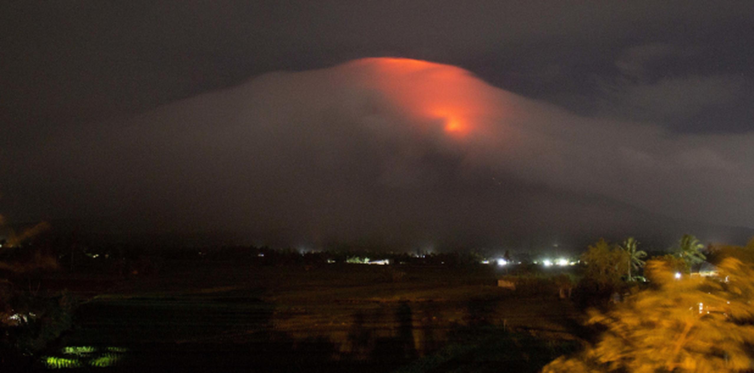 Un resplandor naranja se ve sobre el cráter envuelto en nubes del Mayón, en Legazpi. (AP)