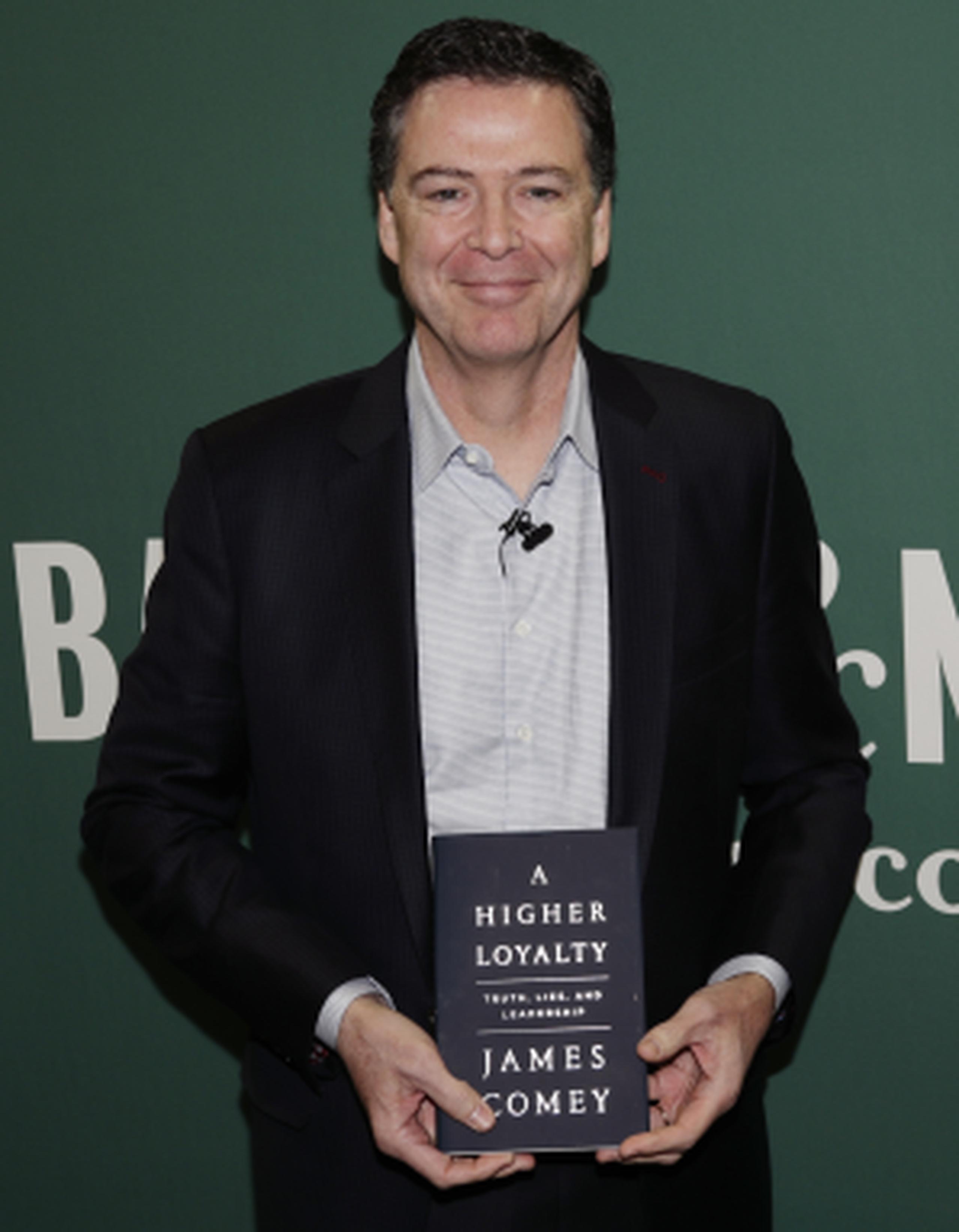 El exdirector del FBI James Comey con su libro. (AP / Frank Franklin II)