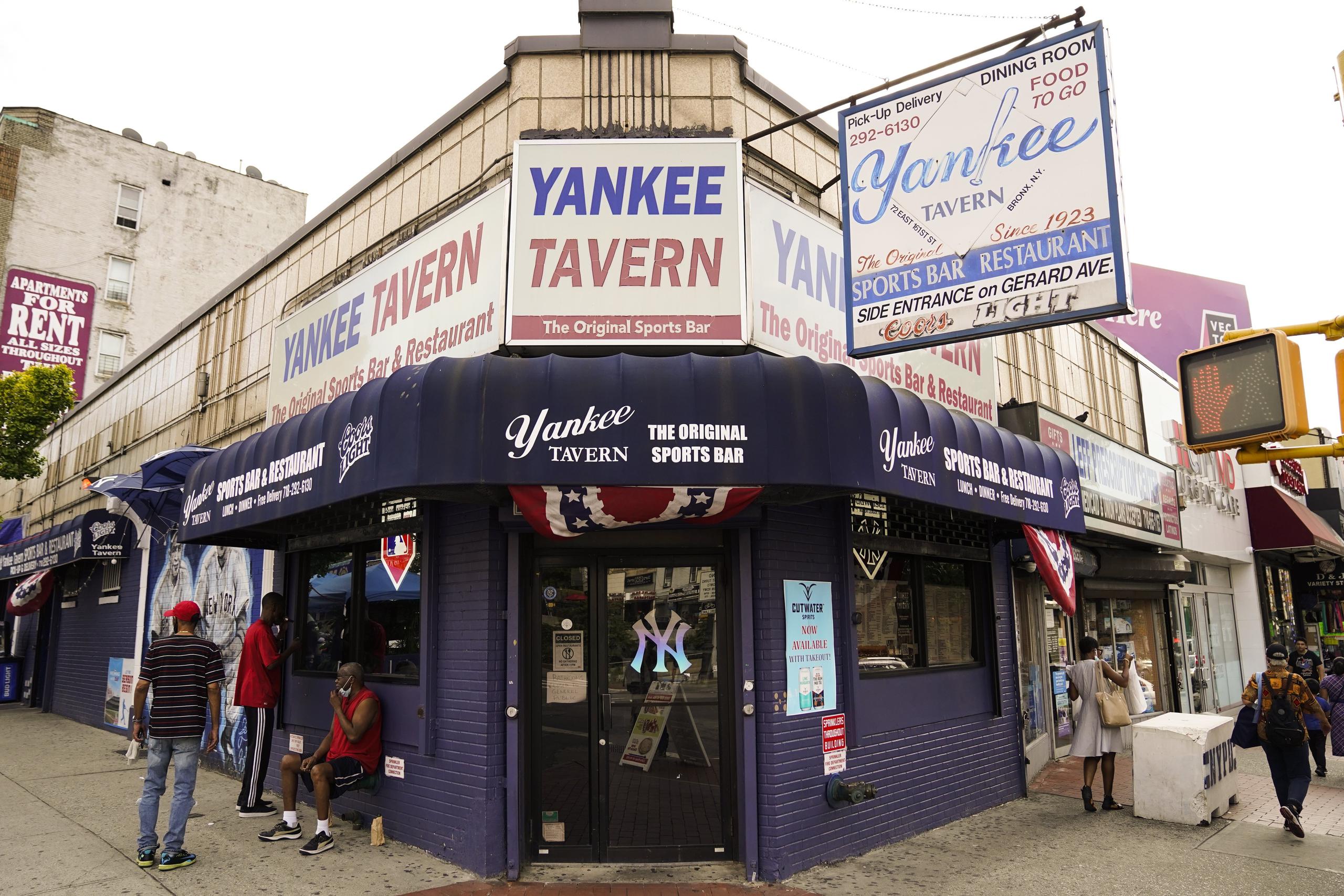 Ciudadanos pasan cerca del Yankee Tavern, que lleva operando desde 1927 pero ha sufrido también el golpe del poco público por la pandemia.