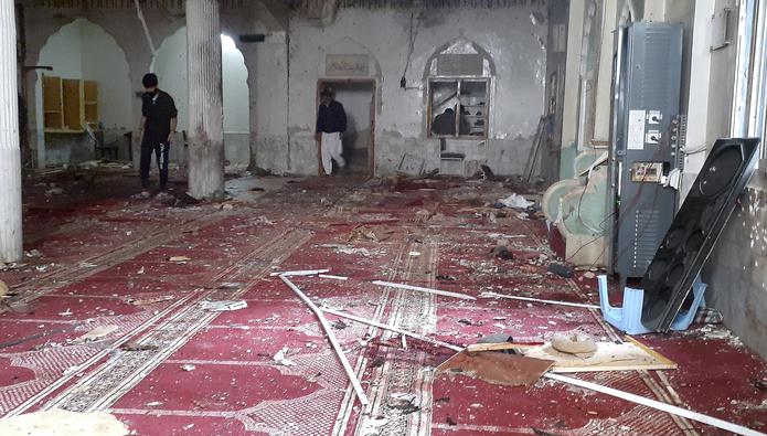 Voluntarios examinan el escenario de una explosión en el interior de una mezquita chií en Peshawar, Pakistán, el 4 de marzo de 2022. (AP Foto/Muhammad Sajjad)