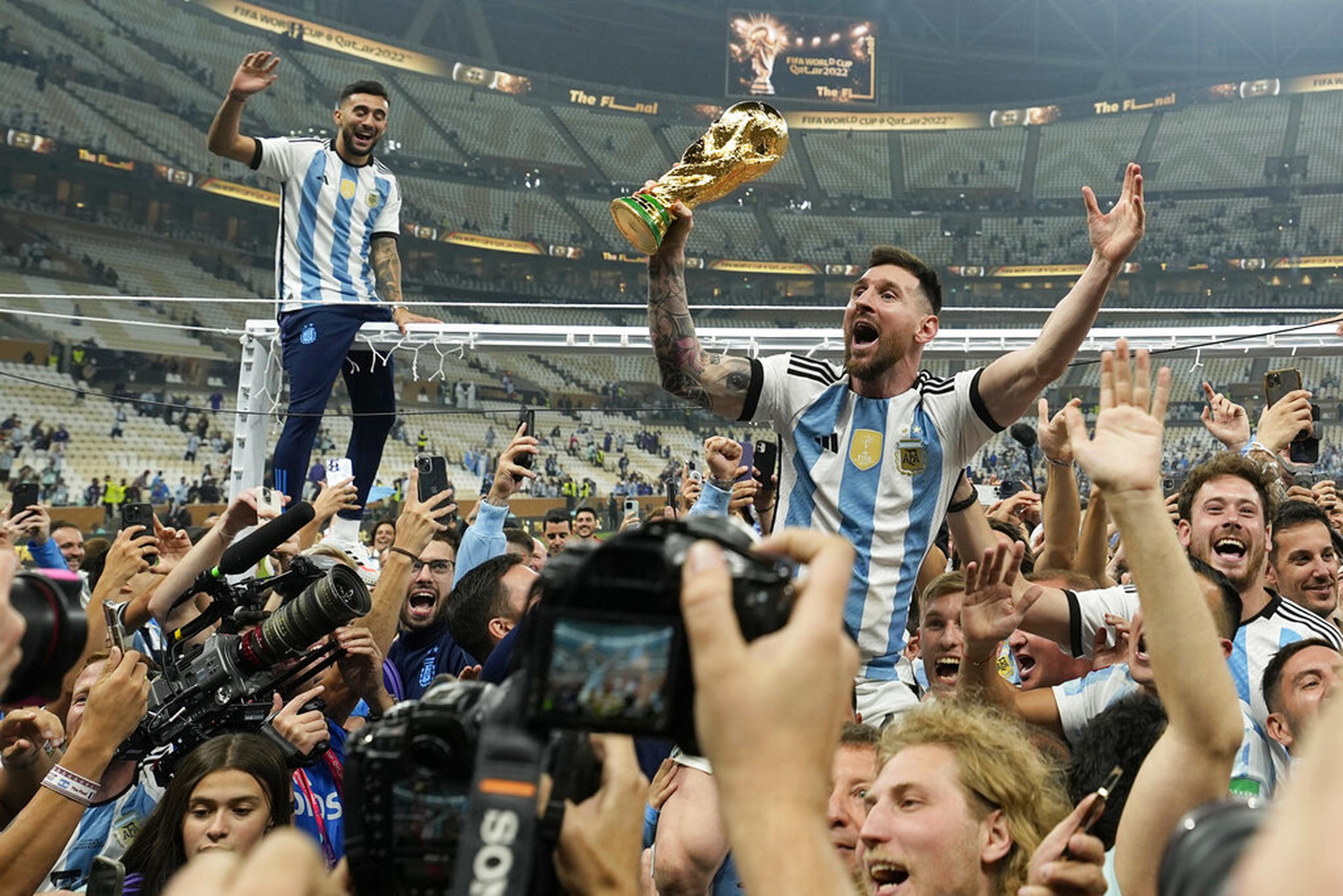El argentino Lionel Messi celebra con el trofeo ante los hinchas tras ganar el Mundial en la final entre Argentina y Francia en el estadio Lusail de Lusail, Qatar.