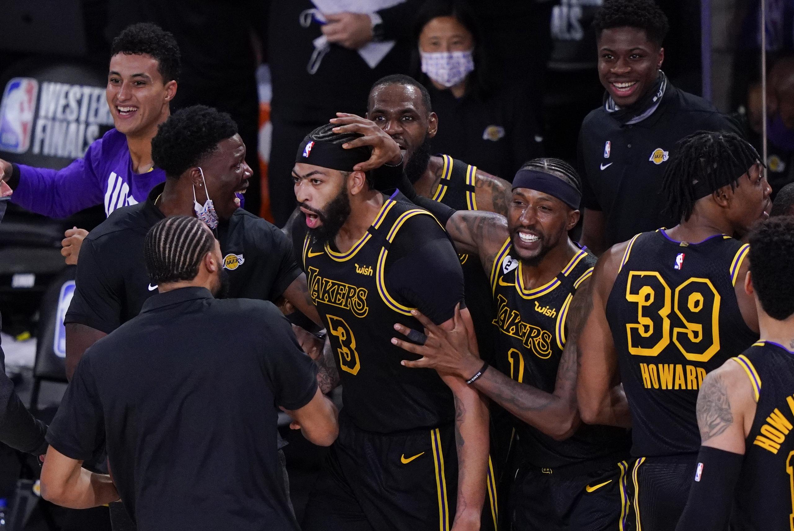 Anthony Davis, de los Lakers, es felicitado por sus compañeros de equipo luego de colar el decisivo canasto del domingo ante los Nuggets de Denver.