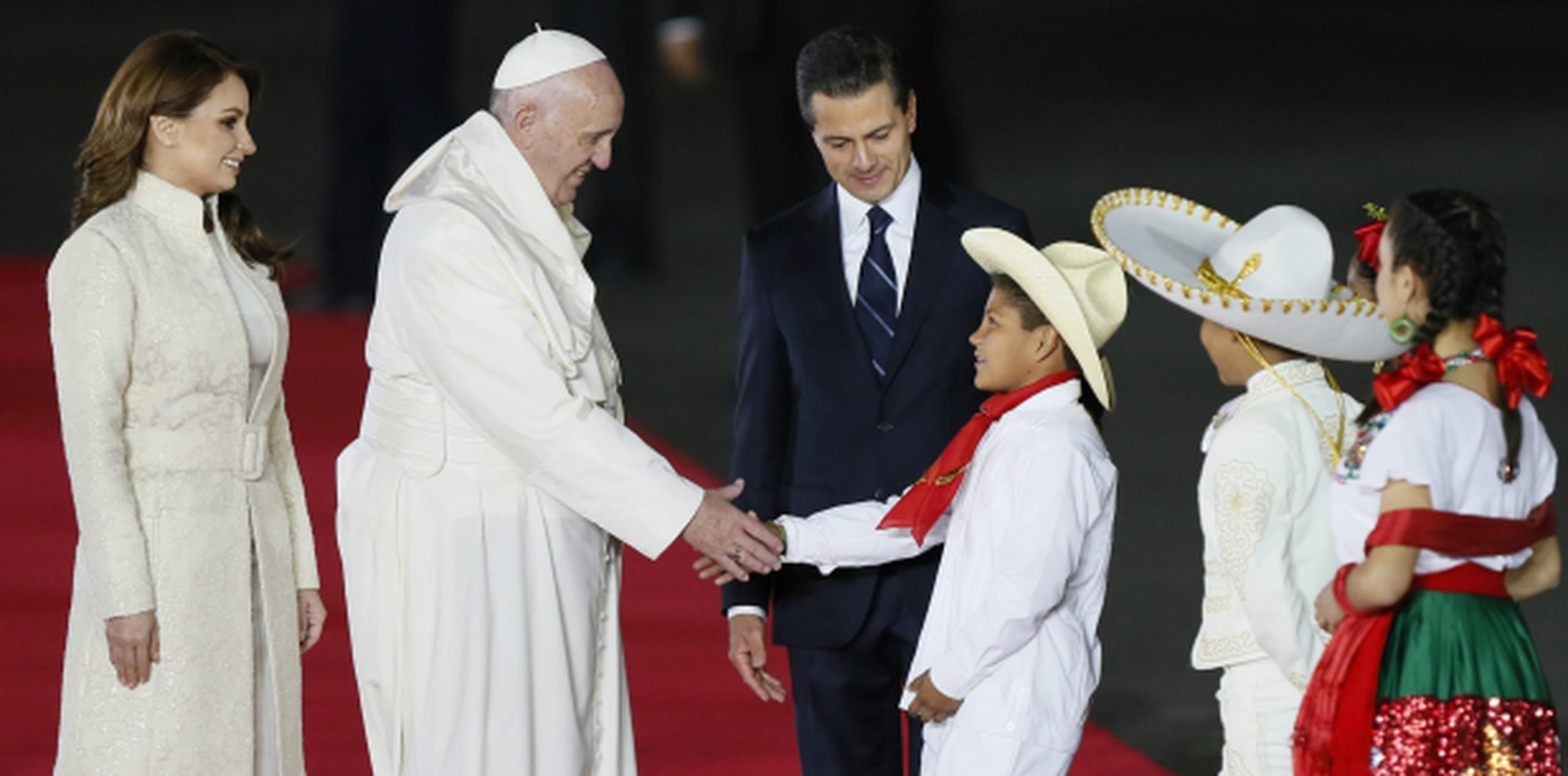 El papa Francisco fue recibido en el Aeropuerto Internacional de Ciudad de México por el presidente Enrique Peña Nieto, la primera dama Angélica Rivera y un grupo de niños. (EFE/José Méndez)

