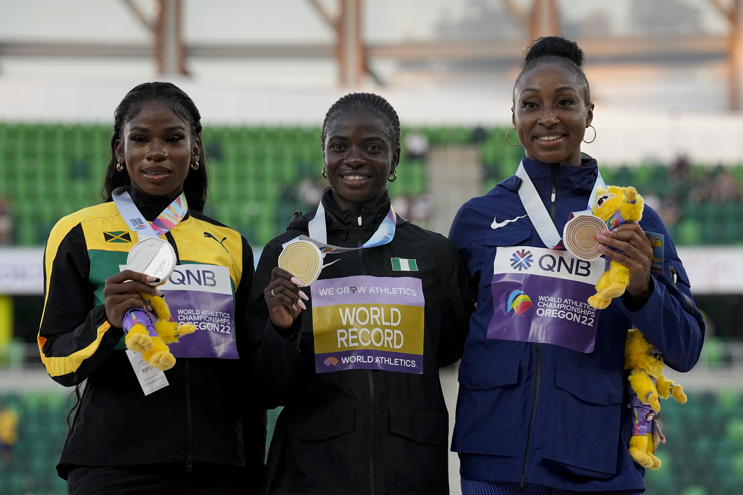 La ganadora de la medalla de oro en el Mundial en Oregon, Tobi Amusan, de Nigeria, al centro, posa junto a Britany Anderson de Jamaica, a la izquierda, y la boricua Jasmine Camacho Quinn, respectivamente ganadoras de la medalla de plata y bronce en la final de los 100 metros con vallas en Oregon. Las tres estarán otra vez en carrera hoy en Lausanne.