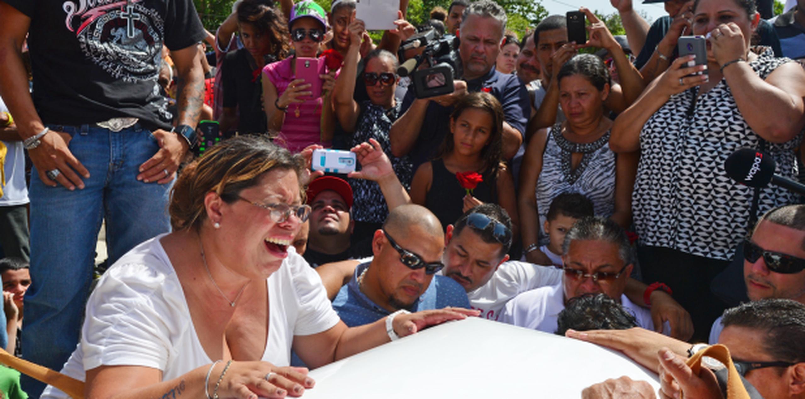 La hermana del fallecido cantante, Luz Divina Perales (primer plano), llora durante el entierro celebrado en Manatí. (LUIS.ALCALADELOLMO@GFRMEDIA.COM)