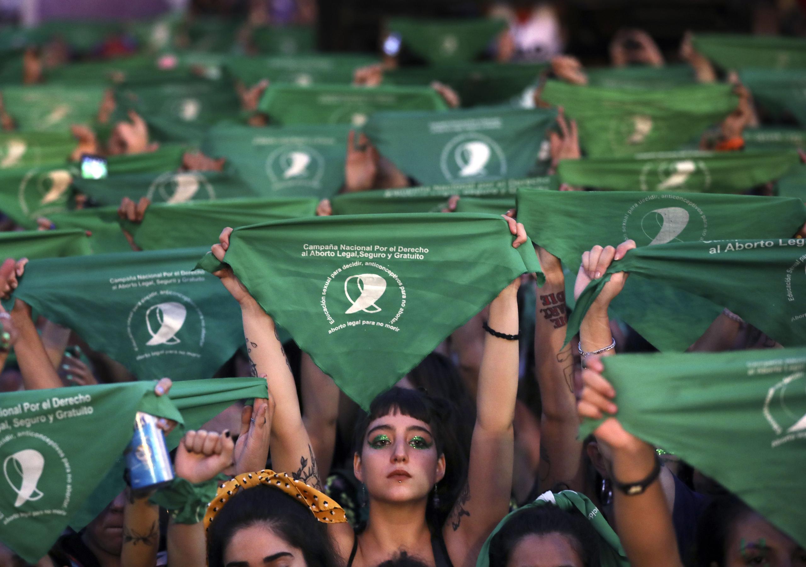 Activistas levantan el emblemático pañuelo verde en favor del derecho de las mujeres a decidir sobre sus cuerpos.