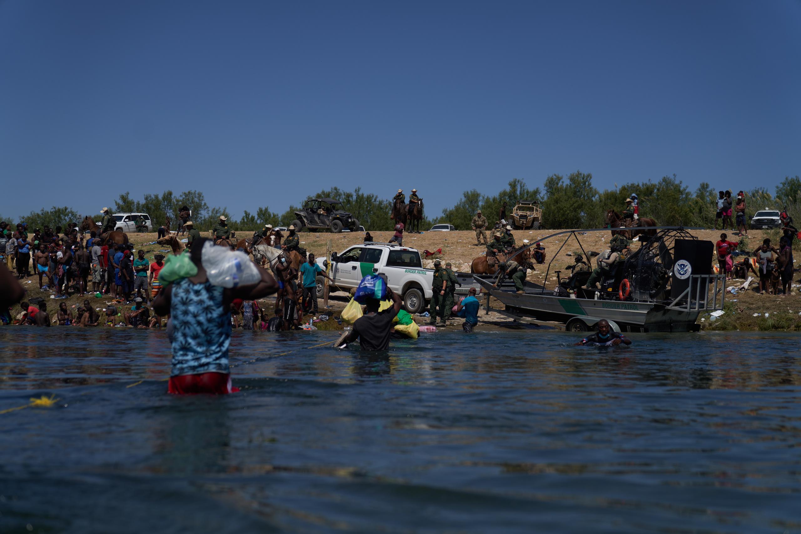 Agentes de la Patrulla Fronteriza de EE.UU. observan mientras migrantes intentan atravesar el Río Grande, desde la ciudad de Acuña, México, el 20 de septiembre de 2021. EFE/Allinson Dinner
