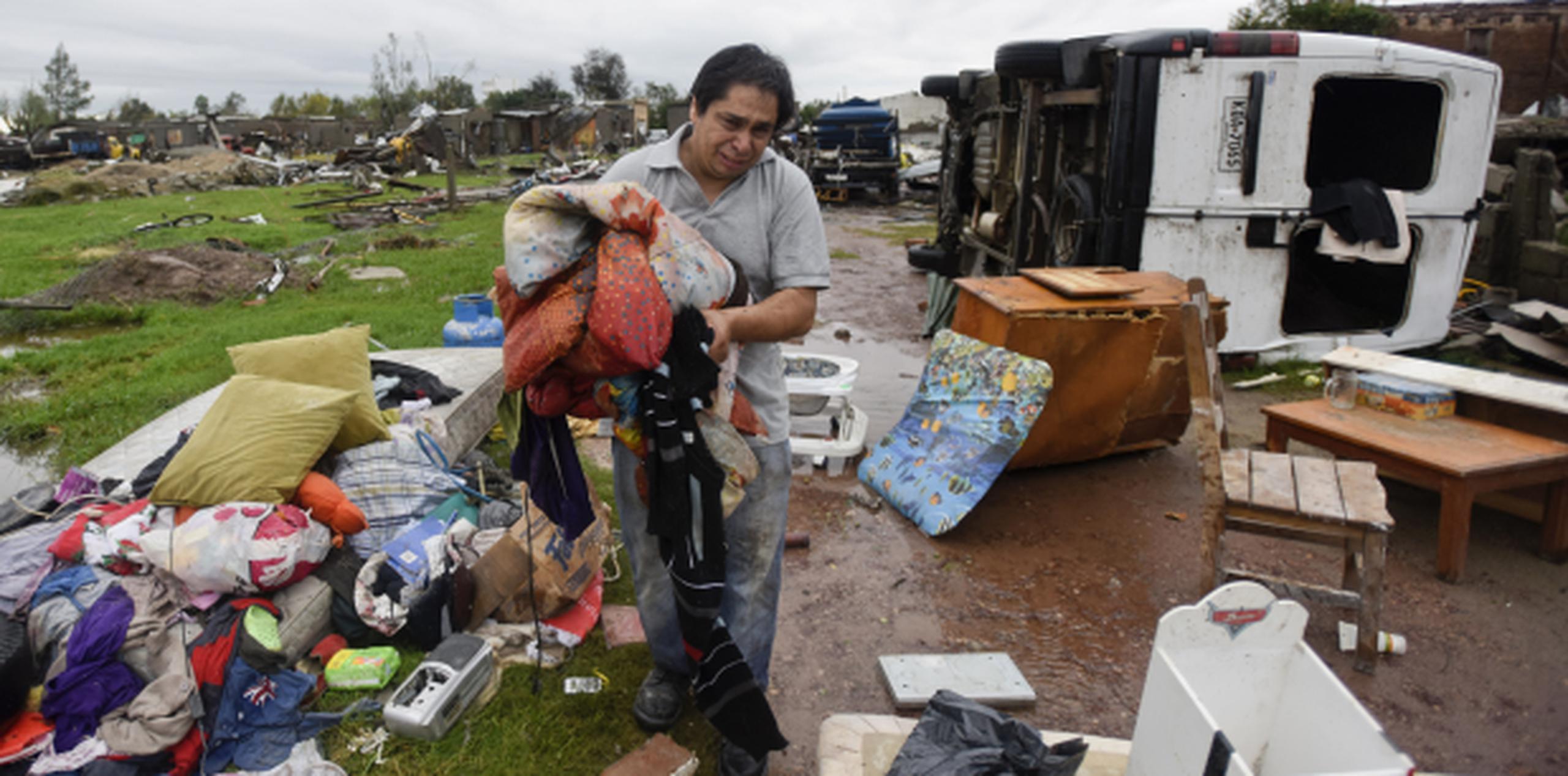Un residente de la ciudad de Dolores llora al recoger sus pertenencias sacudidas por el tornado. (AP / Matilde Campodonico)