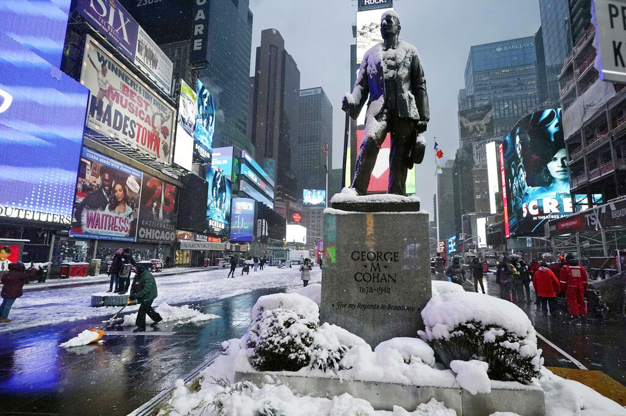 Nieve cubre la estatua del compositor y animador George M. Cohan en Times Square el 7 de enero de 2022.