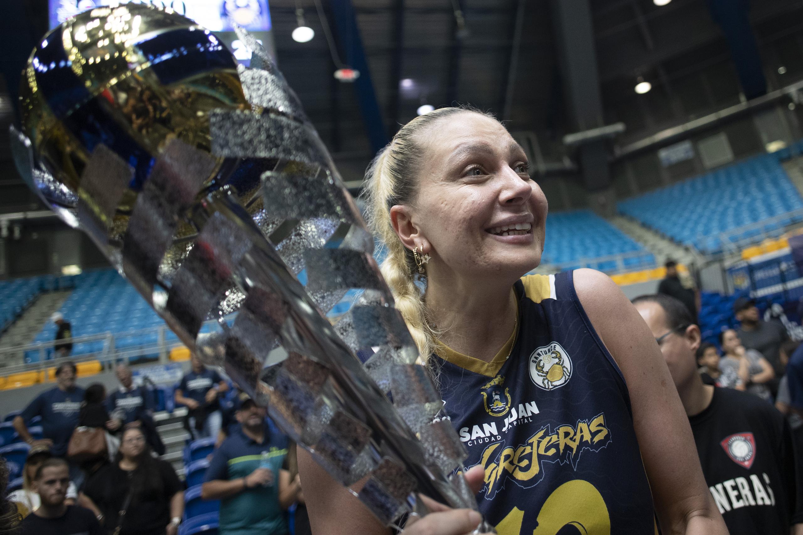 La turca de las Cangrejeras, Yeliz Baza, sostiene el trofeo de campeonas del Voleibol Superior este lunes en Manatí.