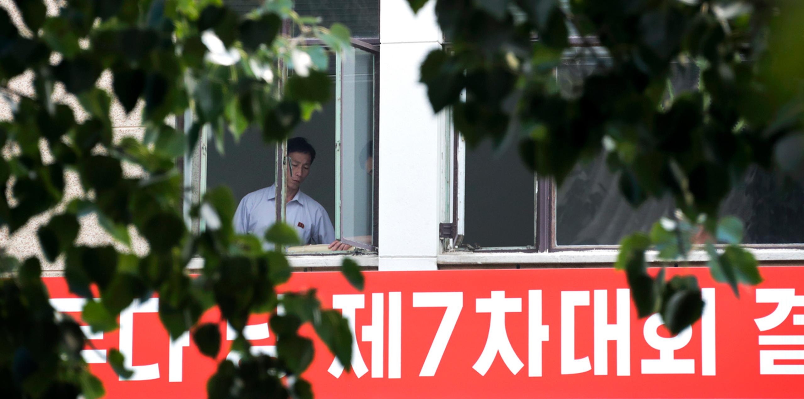Trabajadores norcoreanos hablan cerca de una ventana en la embajada de Corea del Norte en Beijing. (AP)