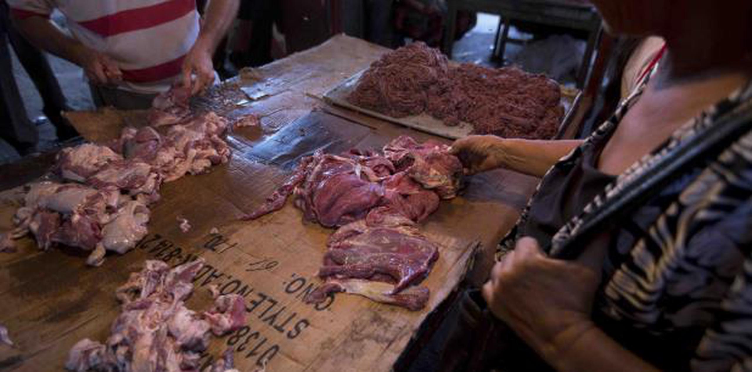 Cliente inspecciona cortes de carne dañada en un mercado de Maracaibo, Venezuela. (AP / Fernando Llano)