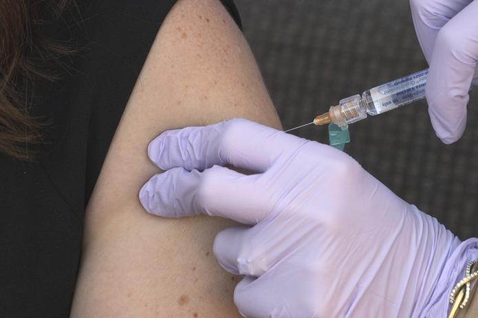 Un miembro del personal de la Fundación Nacional para Enfermedades Infecciosas vacuna a una persona contra la influenza, en Bethesda, Maryland.