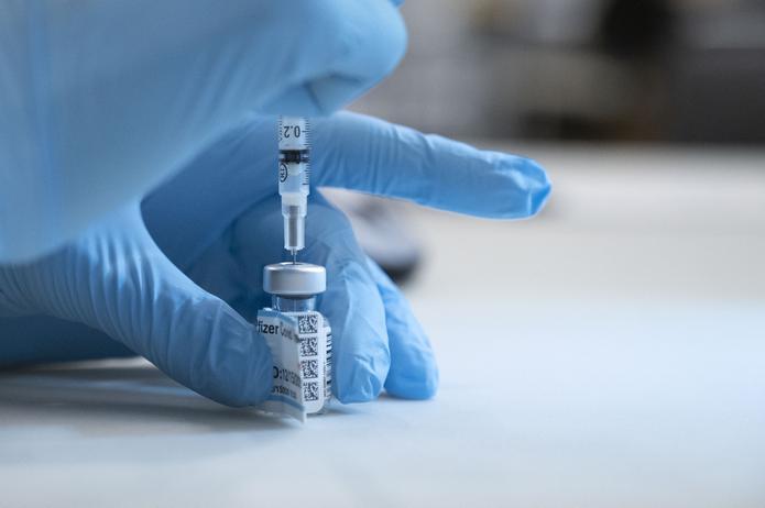Enfermero toma una dosis de la vacuna de COVID-19  desarrollada por Pfizer-BioNTech.