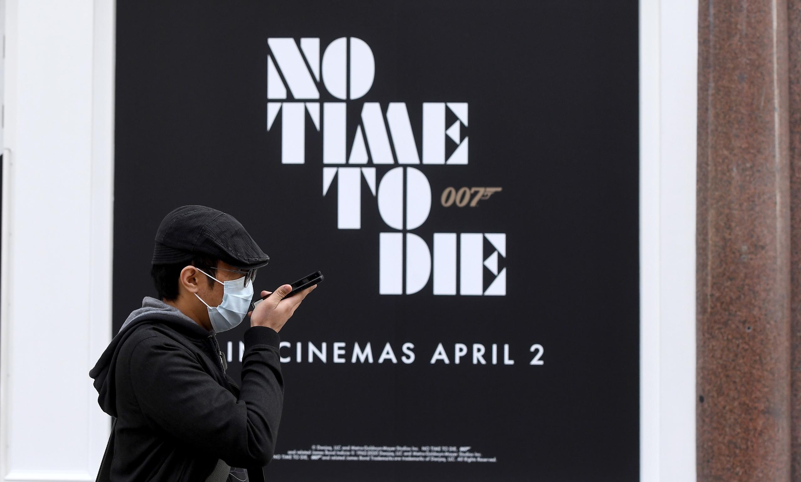 Un hombre pasa por un nuevo anuncio de la película de James Bond 'No Time To Die' en Londres.