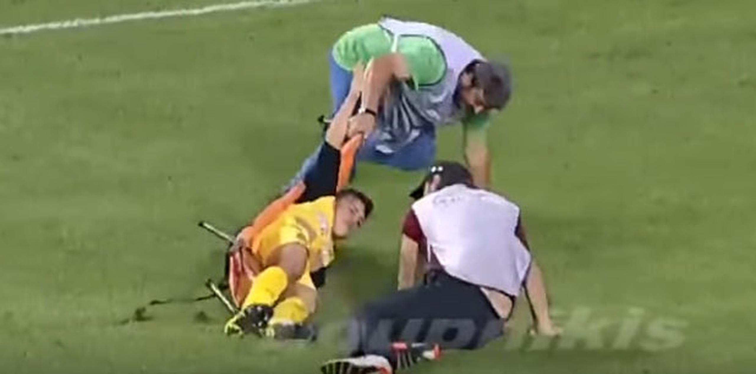 Los camilleros que fueron a asistir al jugador lesionado Leonardo Koutris. (Youtube)