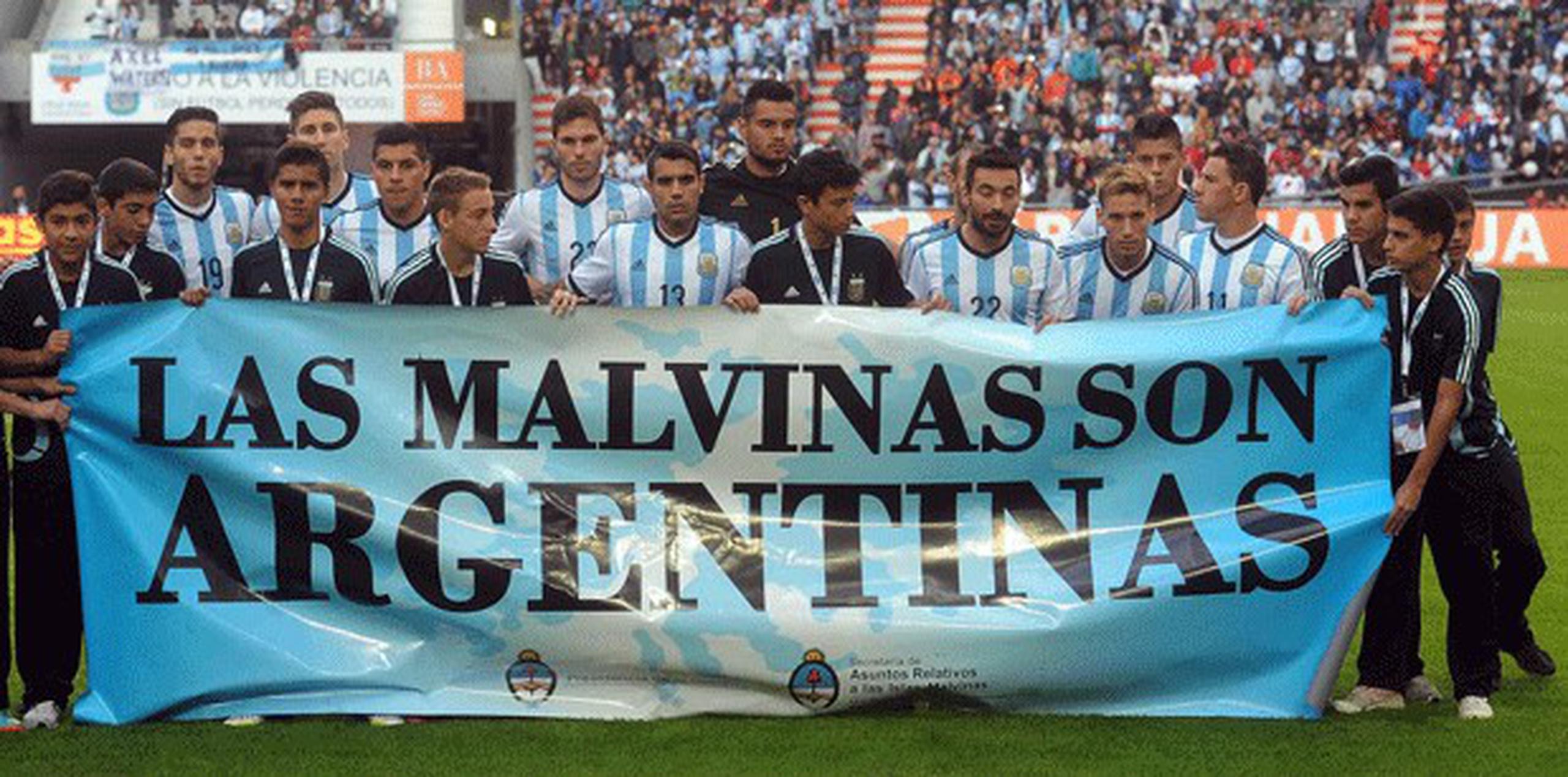 Antes de su triunfo 2-0 sobre Eslovenia el sábado en un amistoso en La Plata, los futbolistas argentinos se pararon detrás de una pancarta con la inscripción: "Las Malvinas Son Argentinas". (AP Photo/Raul Ferrari- Telam)