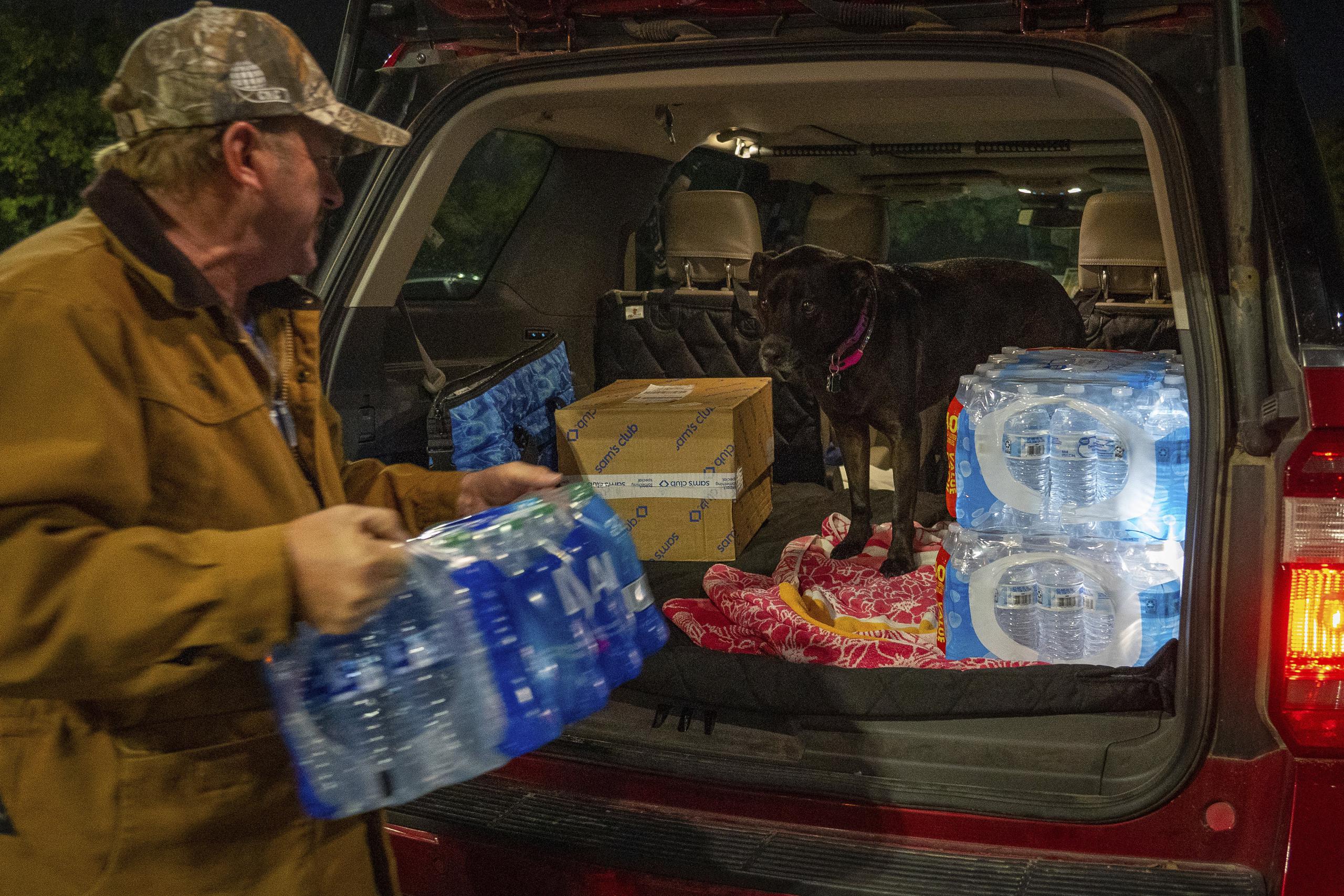 John Beezley, de Bonham, carga varios paquetes de agua embotellada después de enterarse que se emitió un aviso para hervir agua para toda la ciudad de Houston, Texas.