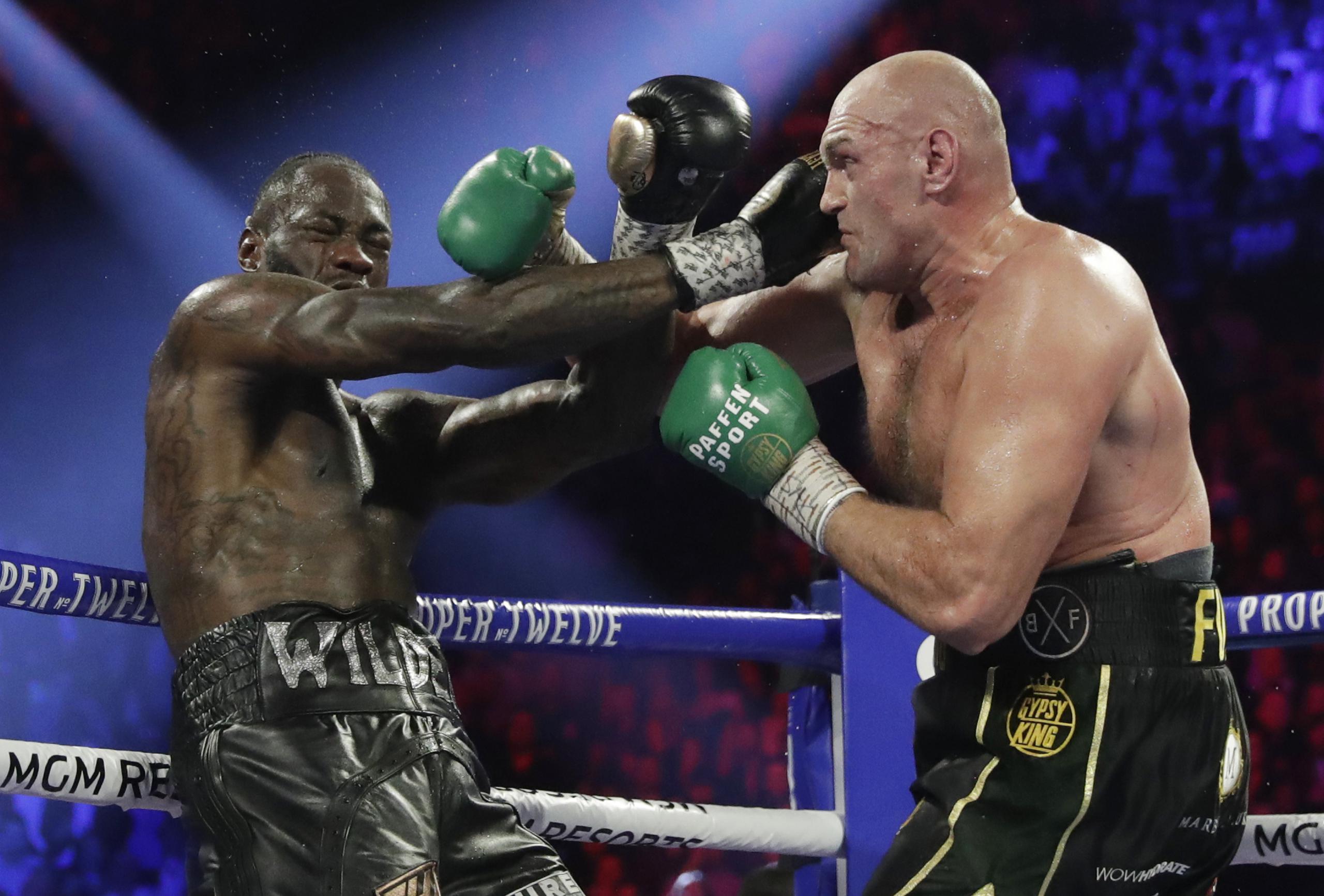 Tyson Fury, conecta a Deontay Wilder anoche durante su pelea en Las Vegas. (AP Photo/Isaac Brekken)