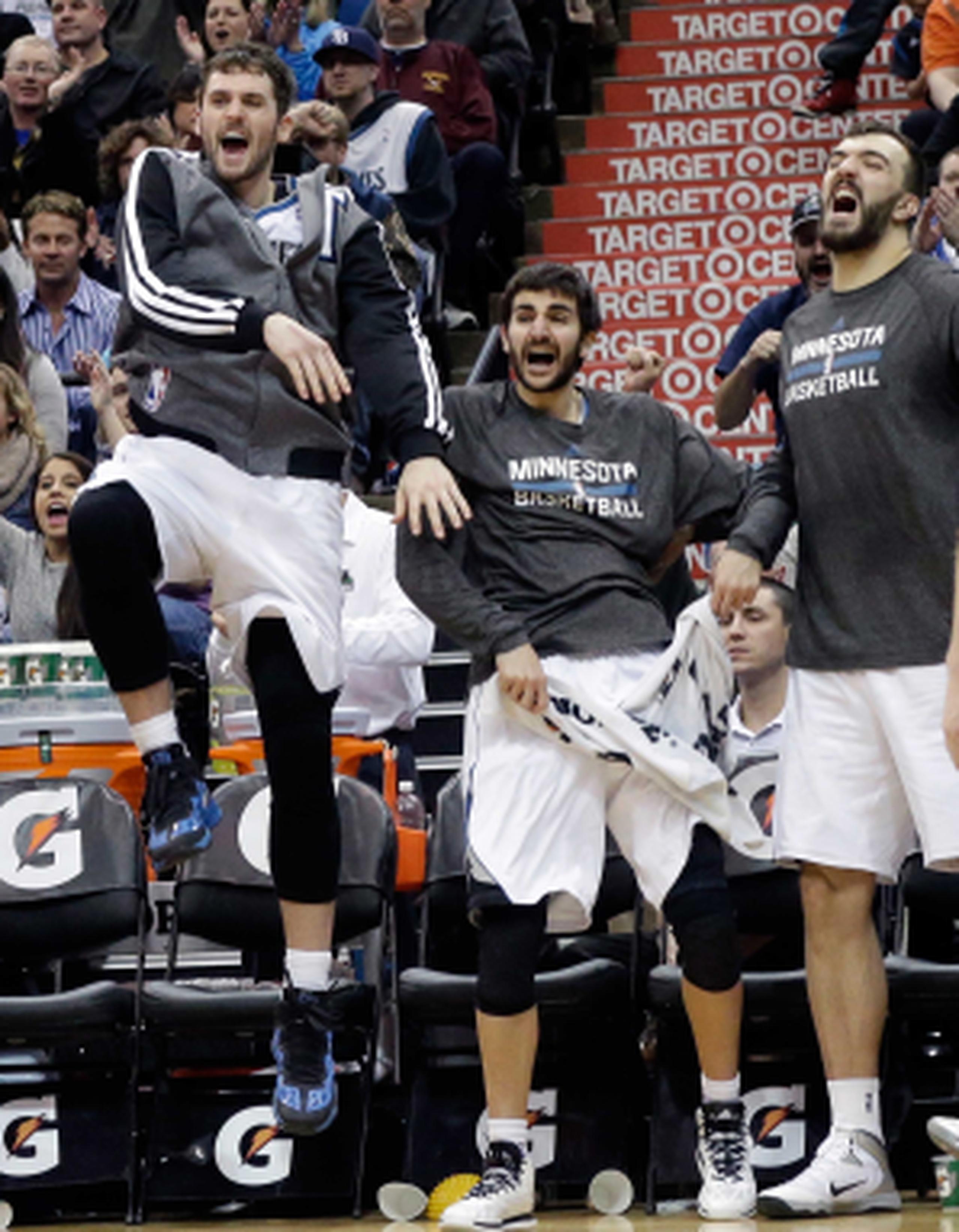 Los jugadores Kevin Love, Ricky Rubio y Nikola Pekovic celebran en el banco de los Timberwolves. (AP /Jim Mone)