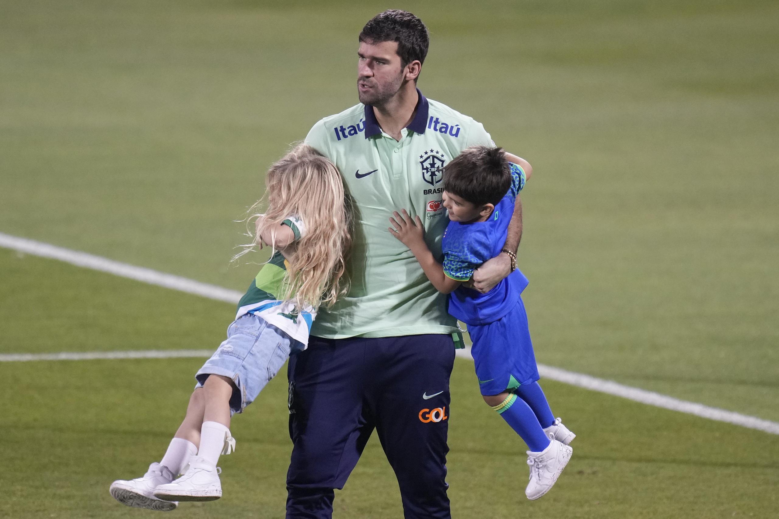 El arquero brasileño Alisson juega con su hija Helena y su hijo Matteo tras un entrenamiento. Brasil enfrentará a Camerún el viernes en el Mundial. (AP Foto/Andre Penner)