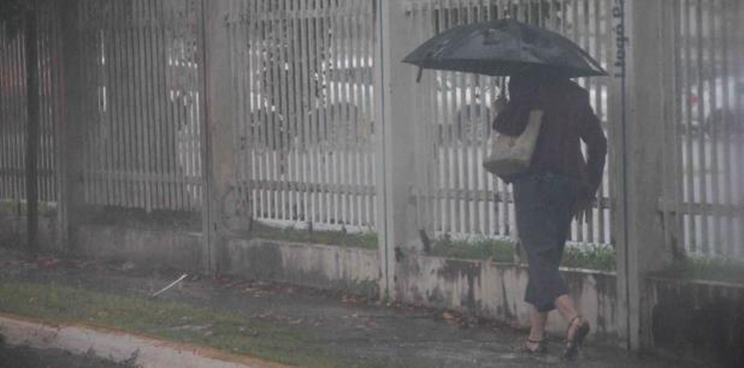 Una mujer se cubre con una sombrilla de la lluvia. (Archivo)