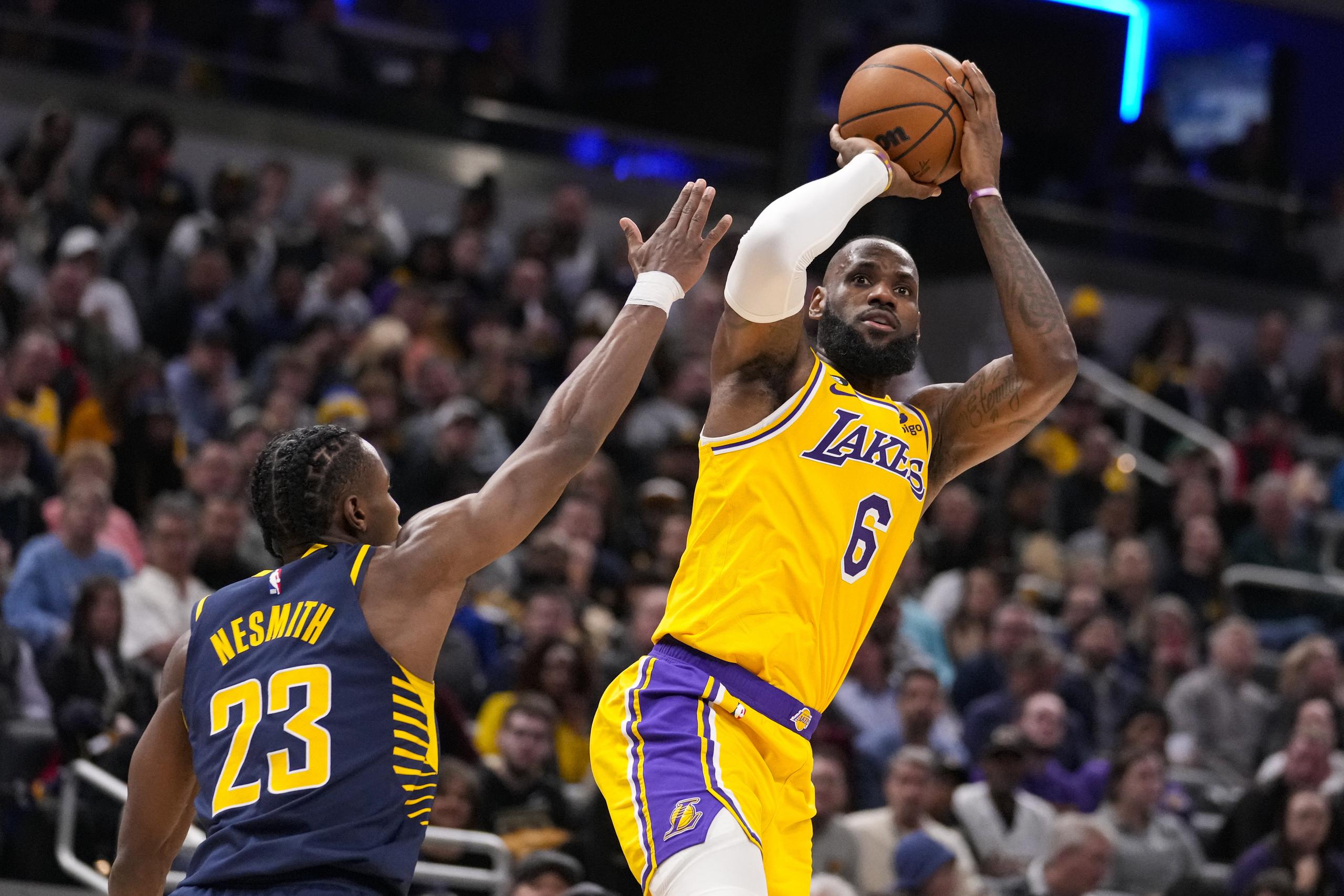 El alero de los Lakers de Los Ángeles, LeBron James, lanza sobre el alero de los Pacers de Indiana, Aaron Nesmith, durante la primera mitad del juego del jueves.