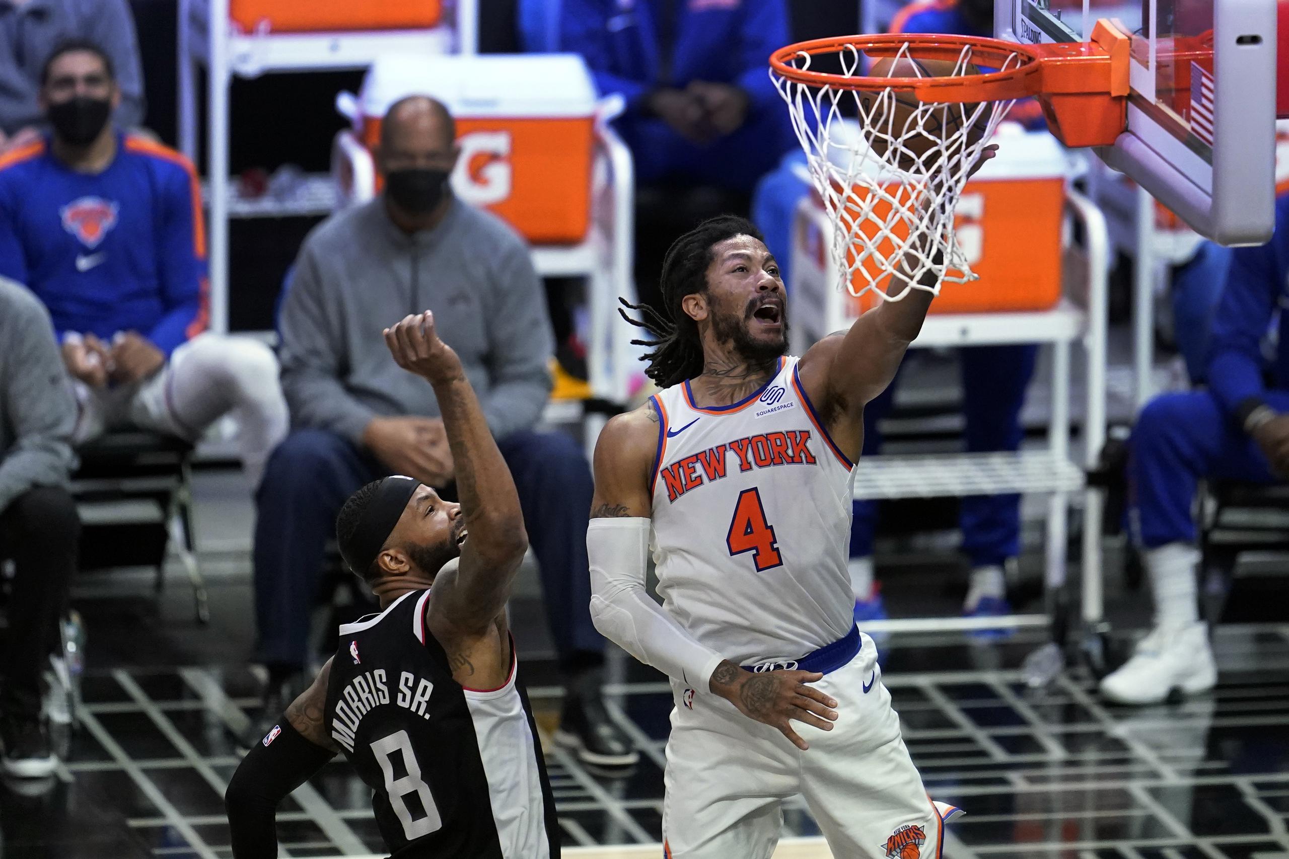 El base de los Knicks de Nueva York Derrick Rose anota superando al alero de los Clippers de Los Ángeles Marcus Morris en el encuentro del domingo 9 de mayo del 2021.