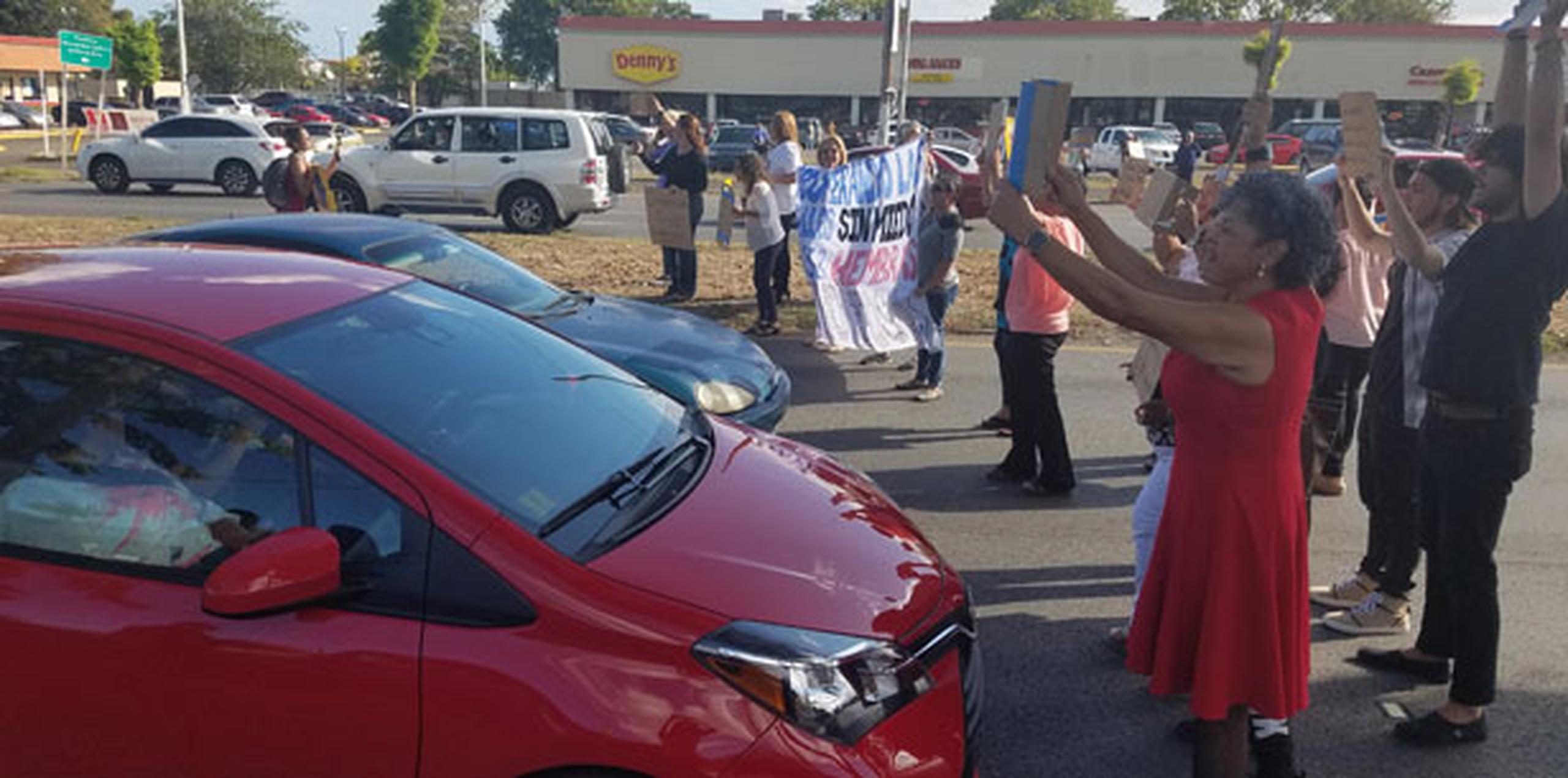 El conductor de un Toyota Yaris rojo casi atropella a tres manifestantes al intentar proseguir la marcha. (michelle.estrada@gfrmedia.com)