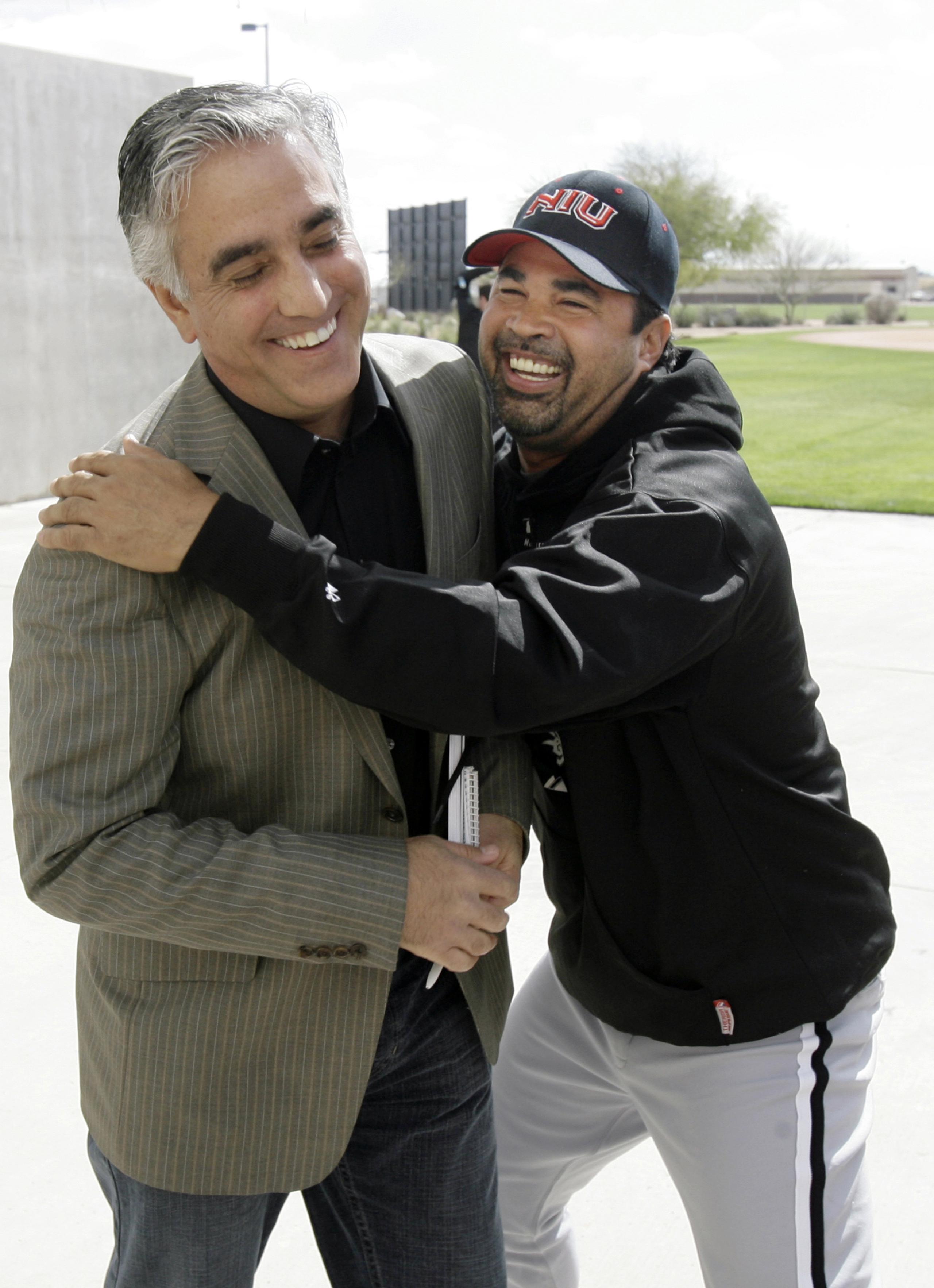 En esta foto de archivo del 2008, el periodista Pedro Gómez es abrazado por el entonces piloto de los White Sox, Ozzie Guillén.