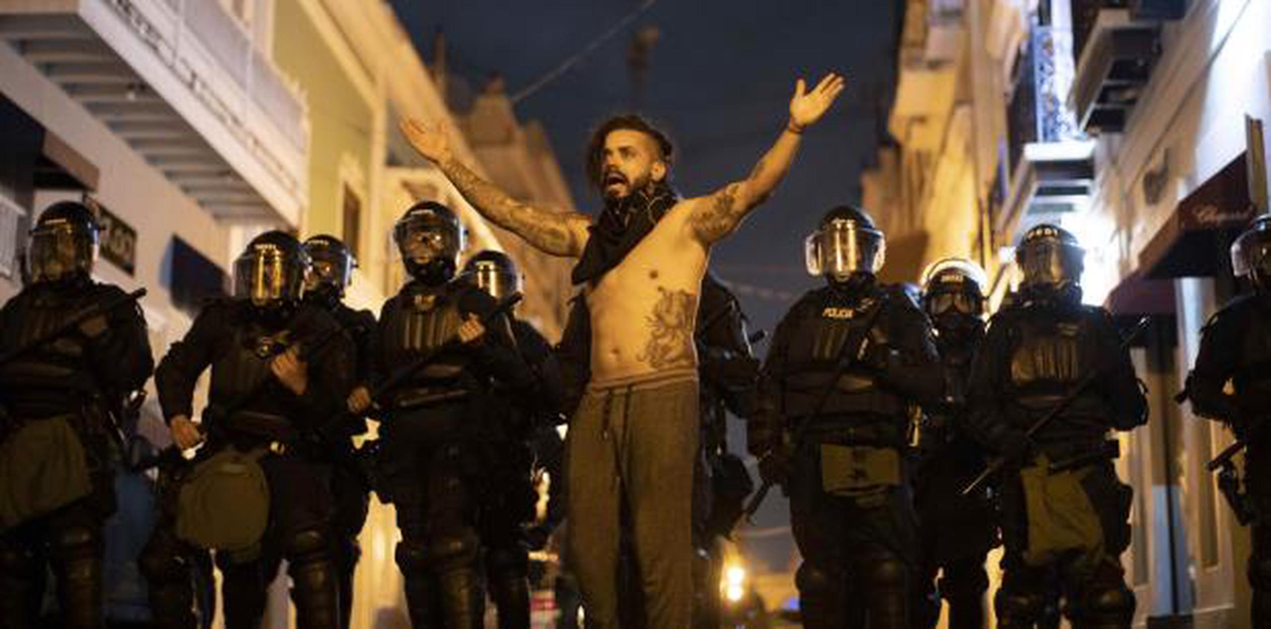 Un ciudadano protesta en presencia de diversos policías anoche en Viejo San Juan. (archivo)
