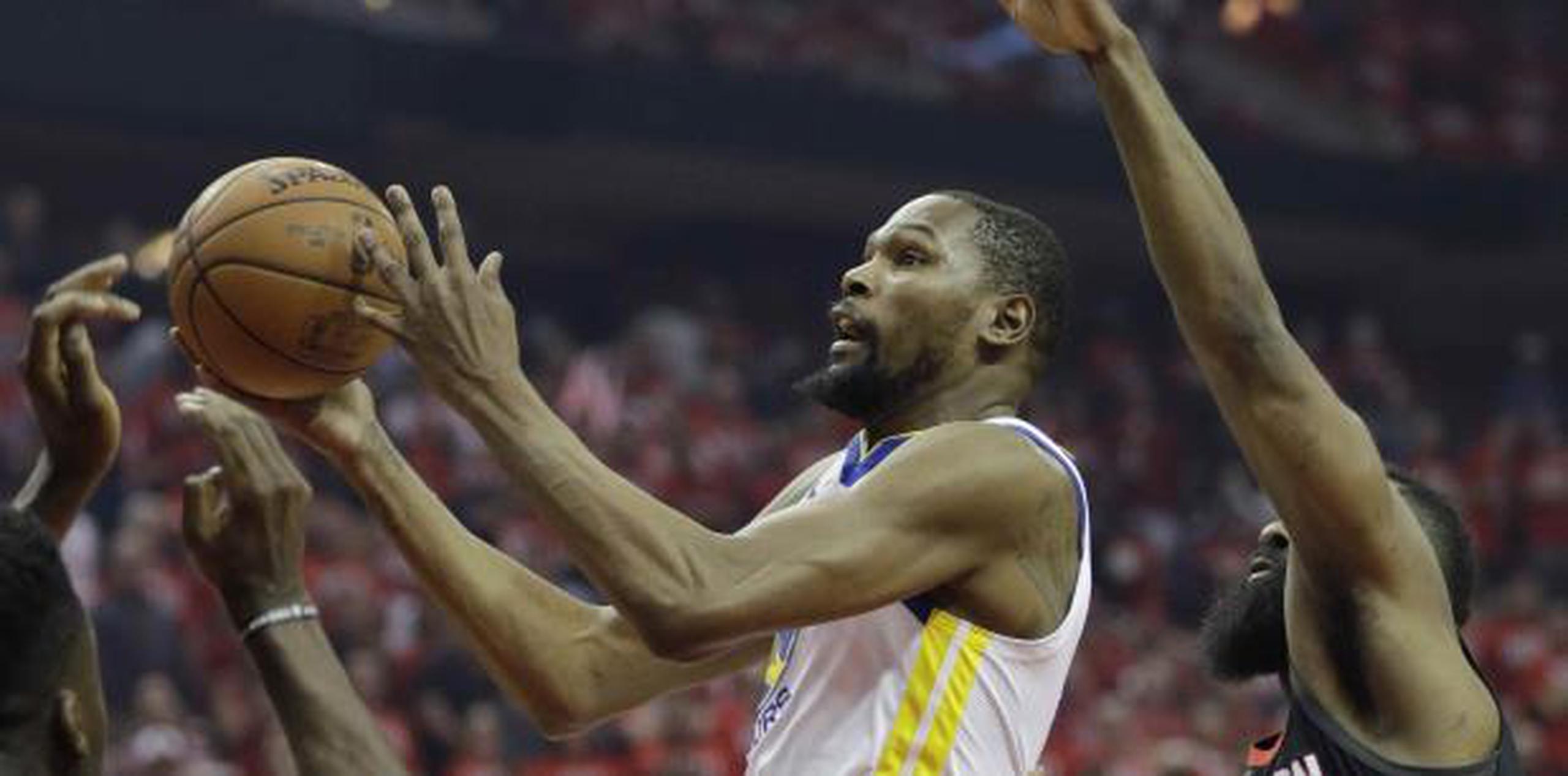 El alero de los Warriors de Golden State, Kevin Durant, ataca el aro y deja atrás a James Harden, de los Rockets de Houston. (AP Foto/David J. Phillip)