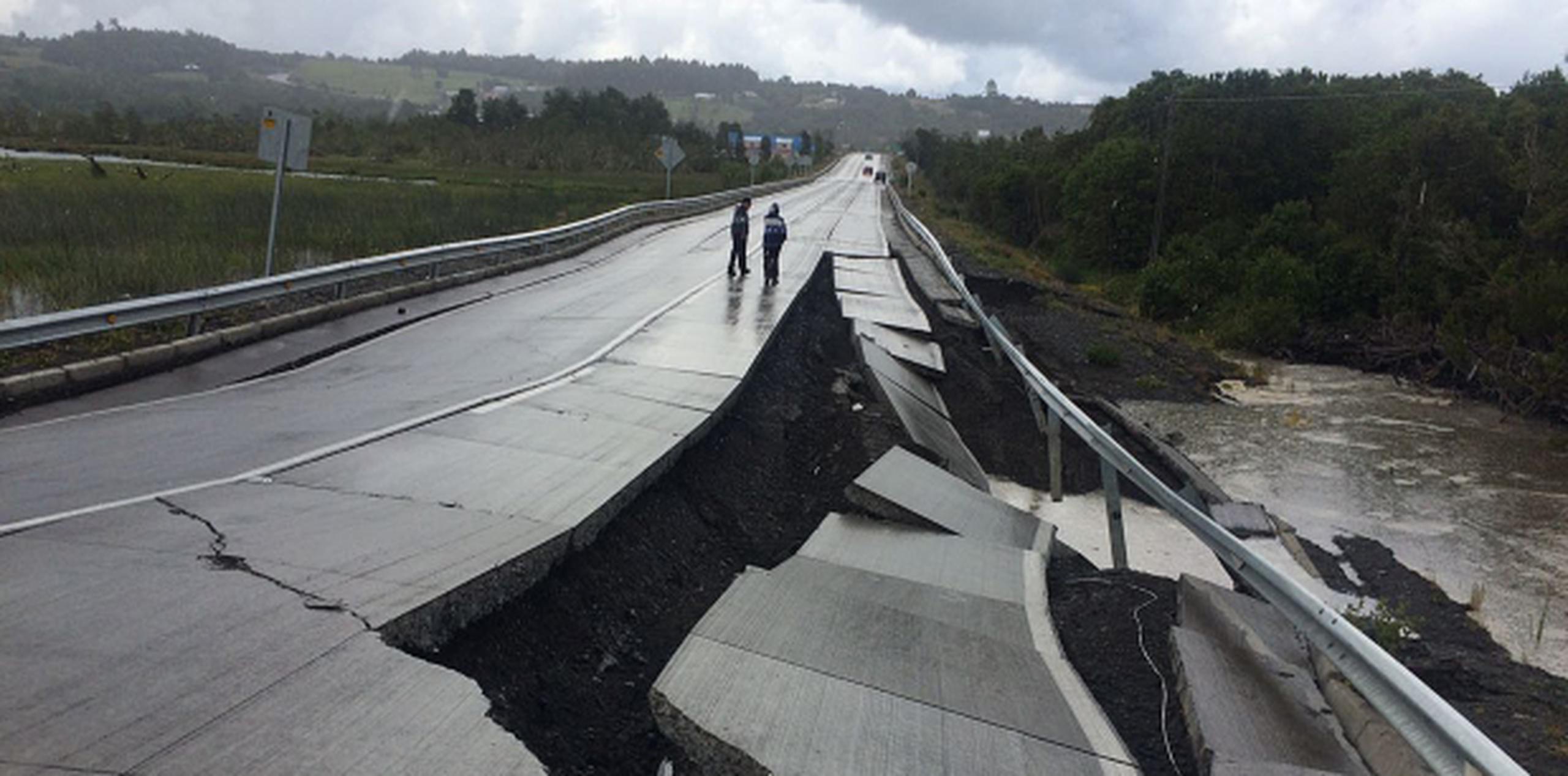 Personas caminan por una carretera destruida en Tarahuin, en la isla de Chiloe. (Agencia EFE)