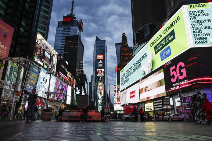 Una pantalla muestra mensajes relacionados con el coronavirus en Times Square, que está casi vacío, en Nueva York.