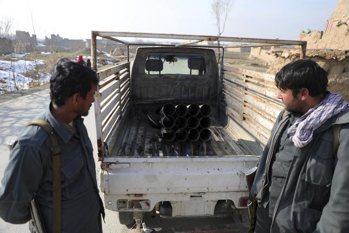 Personal de seguridad afgano vigila un vehículo en el cual se instalaron cohetes, en Bagram, cerca de Kabul, Afganistán. Se dispararon cinco cohetes a una base de Estados Unidos en ese país, los que no provocaron bajas.