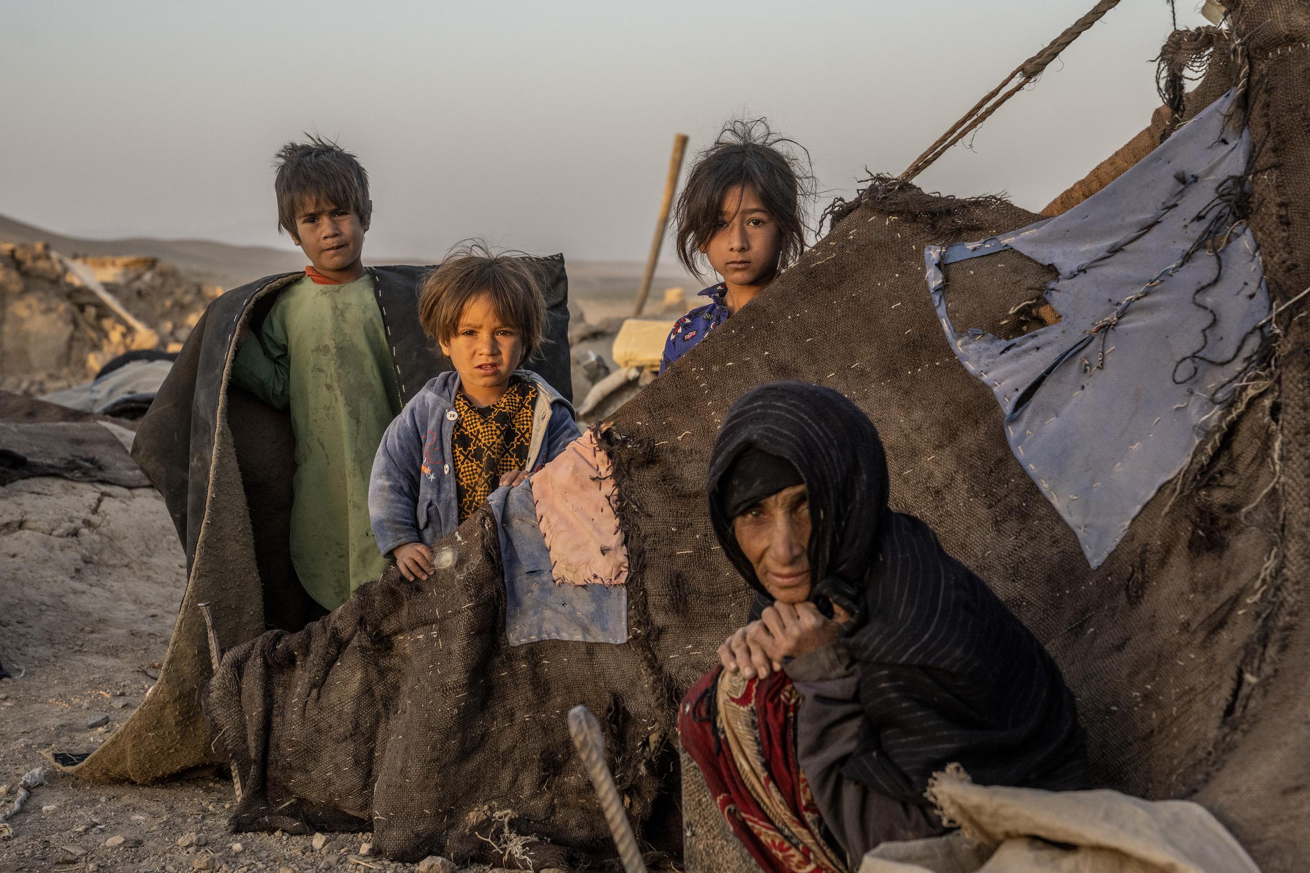 Una mujer afgana y sus niños son vistos en medio de la destrucción después de un terremoto en el distrito de Zenda Jan, en la provincia de Herat, en el oeste de Afganistán, el 11 de octubre de 2023.