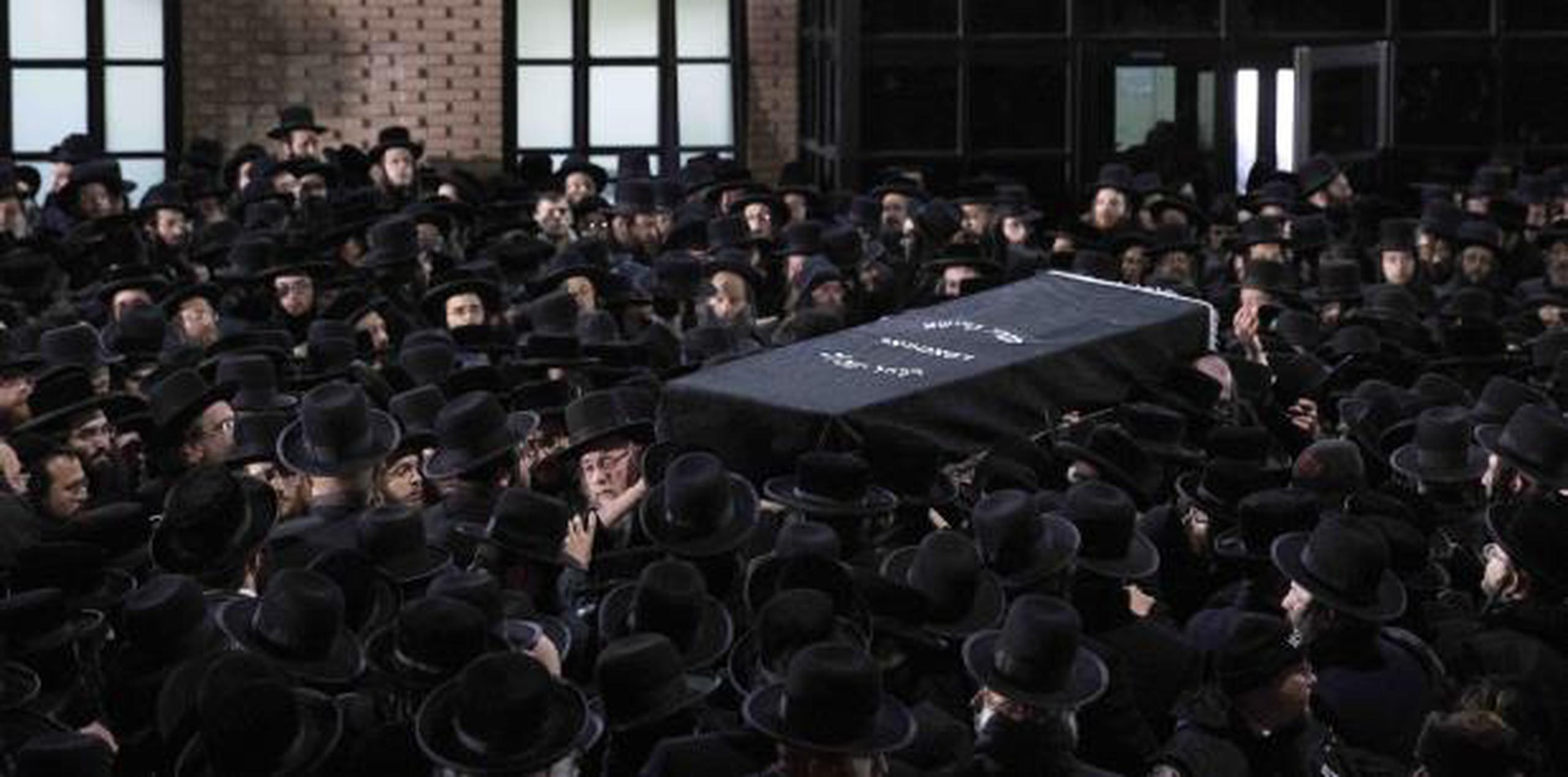 Judíos ortodoxos llevaron el ataúd de Moshe Deutsch afuera de una sinagoga de Brooklyn después de su funeral ayer, miércoles. (AP / Mark Lennihan)
