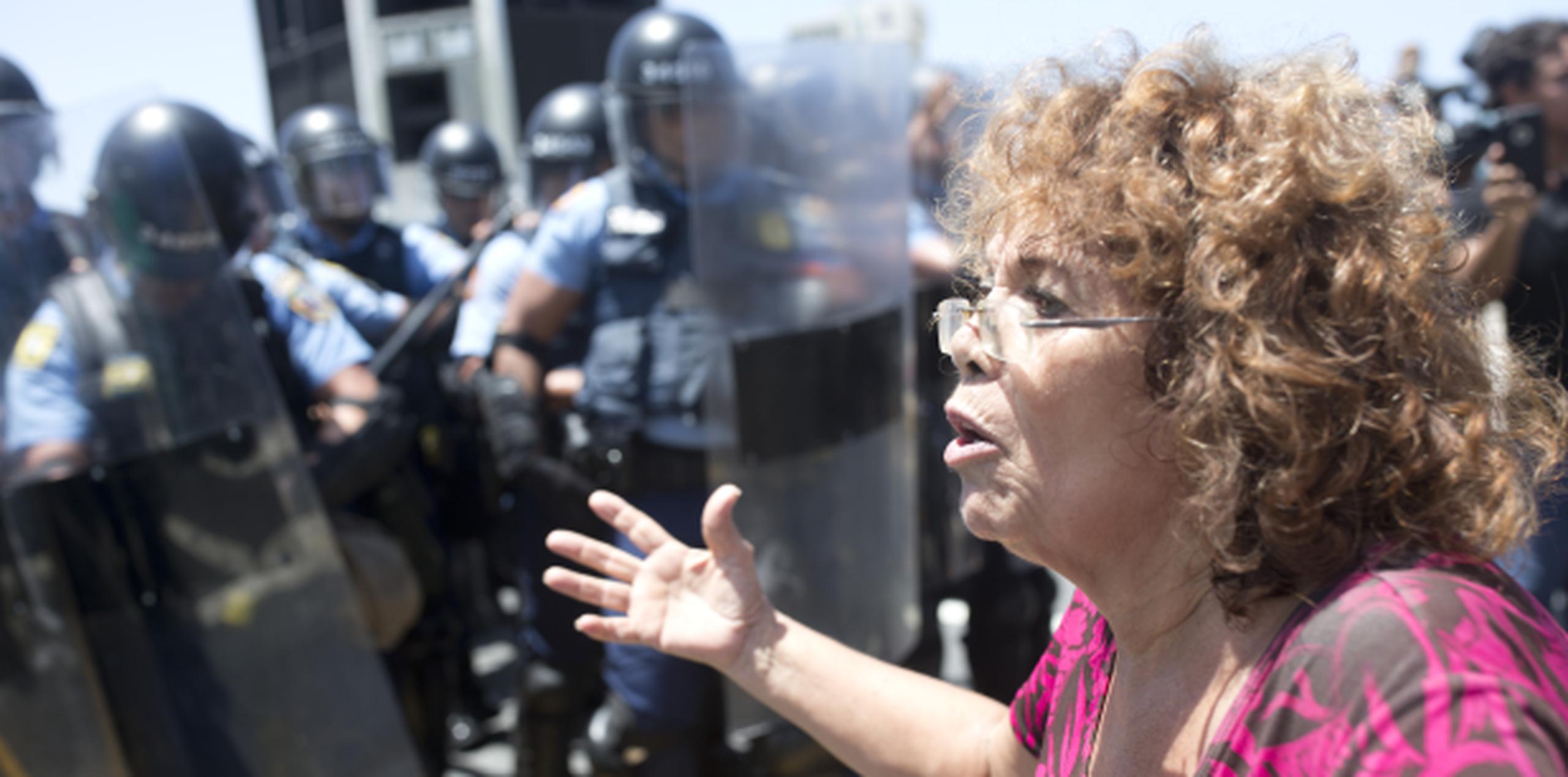 Una mujer le habla a los policías que encararon a los manifestantes opositores a la junta. (xavier.araujo@gfrmedia.com)