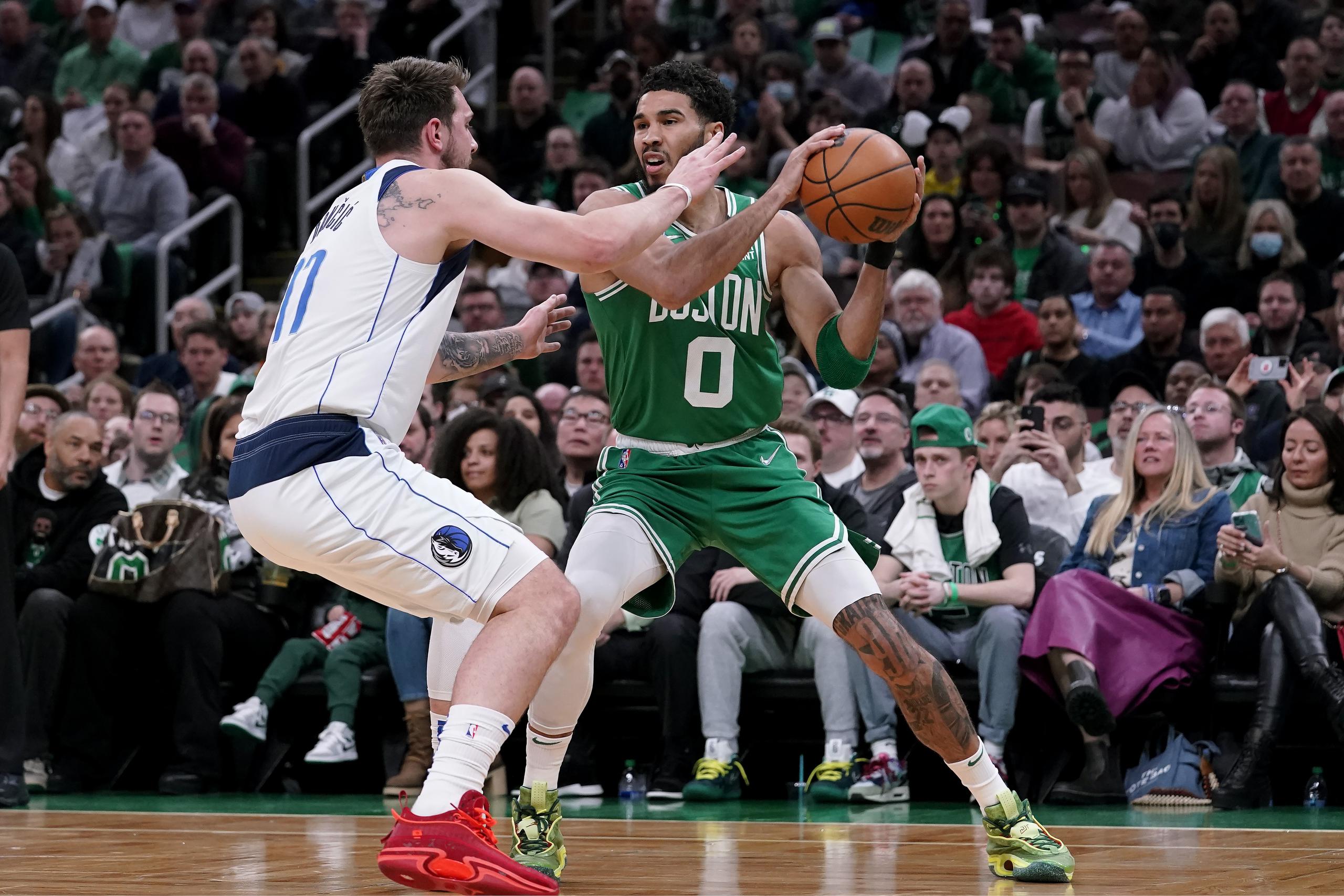 Jayson Tatum (0), de los Celtics de Boston, busca pasar el balón ante la marca del esloveno Luka Doncic, de los Mavericks de Dallas.