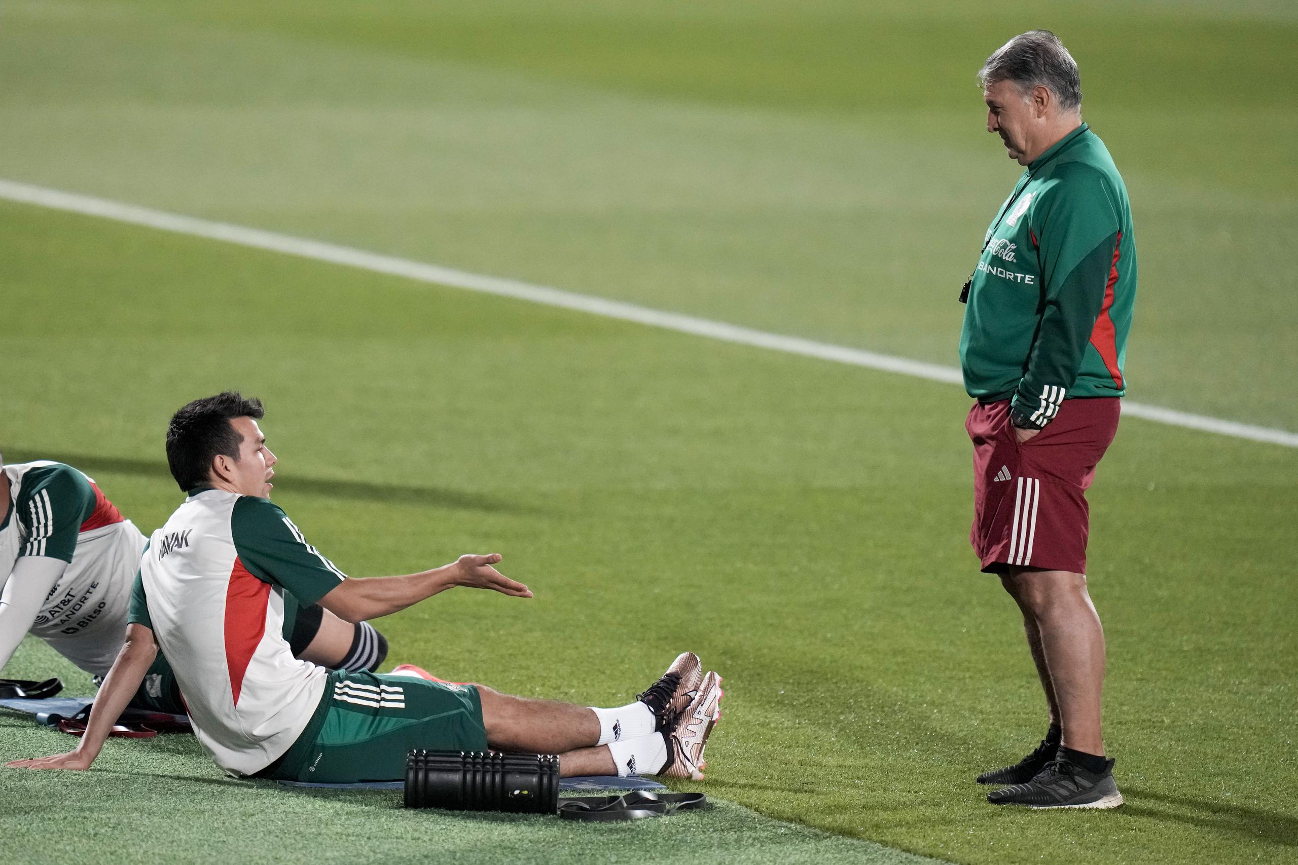 El técnico de México Gerardo Martino (derecha) charla con Hirving Lozano durante un entrenamiento en Jor, Qatar, el domingo 27 de noviembre de 2022. México enfrentará a Arabia Saudí en el Mundial el miércoles. (AP Foto/Moisés Castillo)