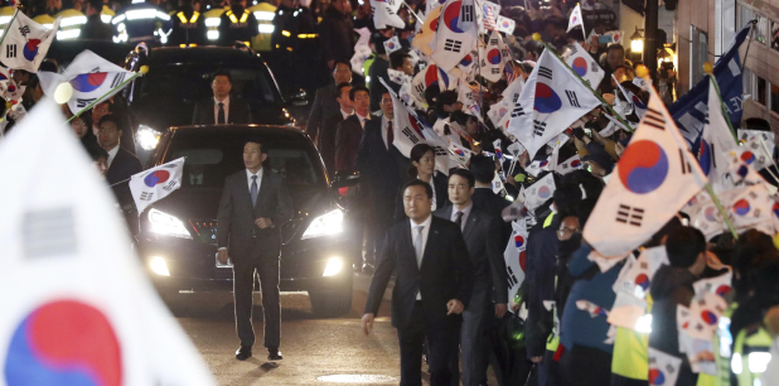 El auto en que viajaba la destituida presidenta Parki Geun-hye llega a la residencia privada en medio del apoyo de simpatizantes. (AP)
