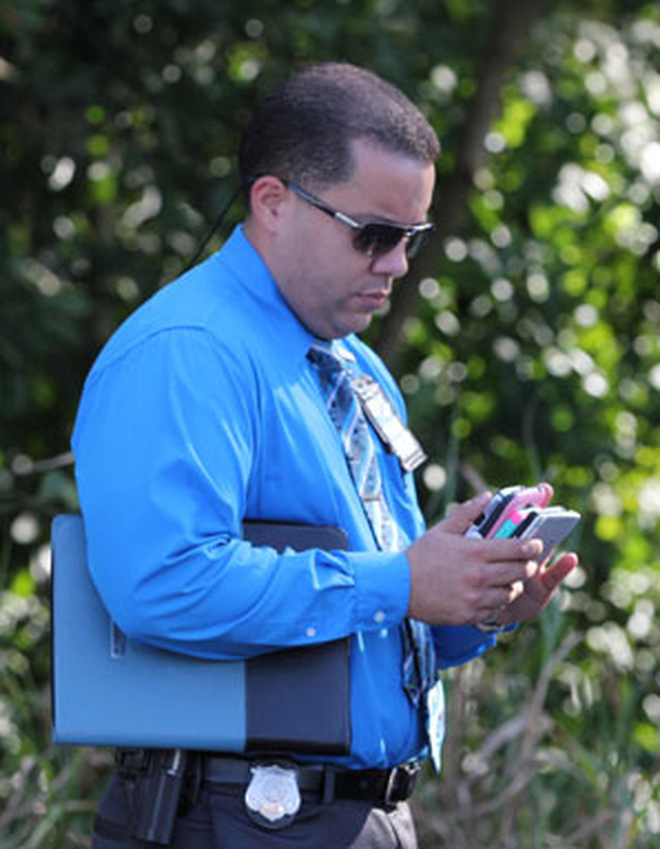 Un agente ocupó celulares de curiosos durante una escena. (alex.figueroa@gfrmedia.com)
