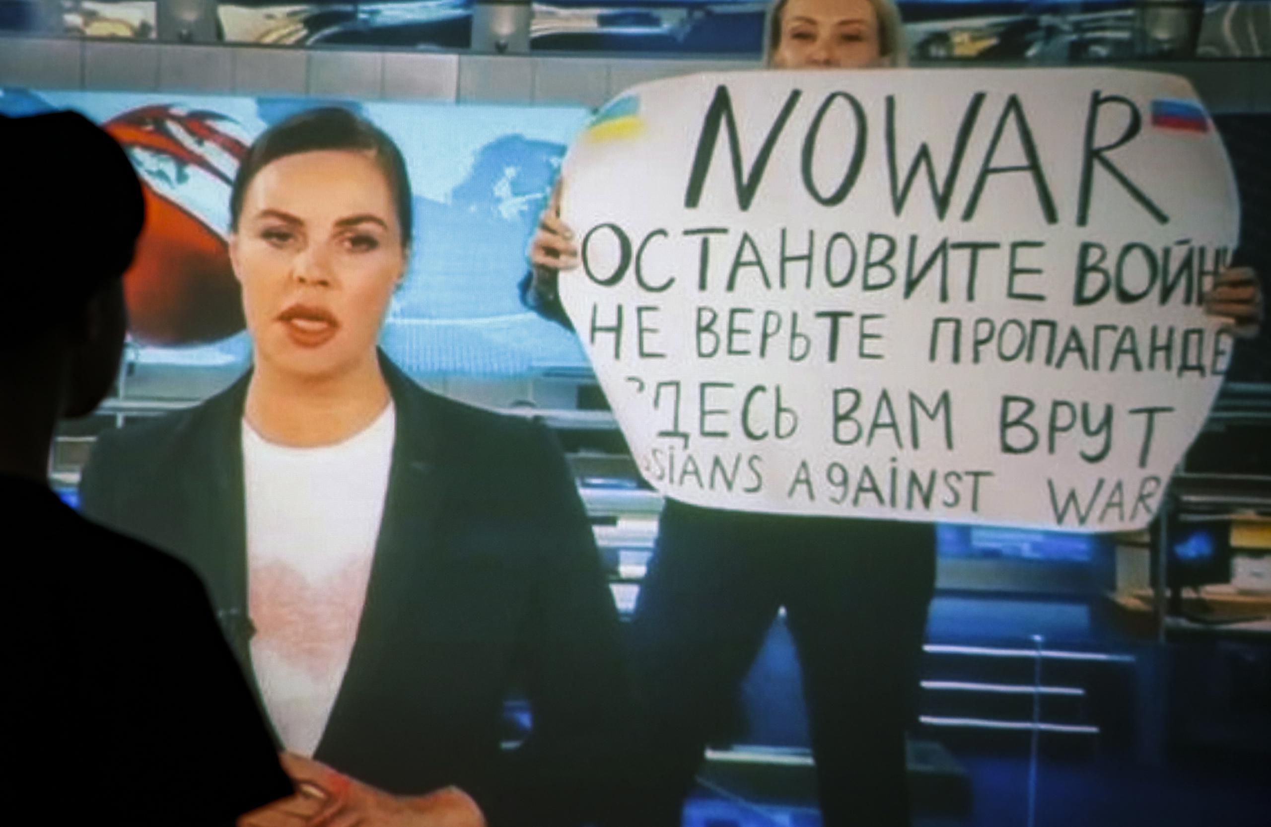 Una mujer ve una transmisión grabada del programa de televisión de noticias del canal ruso Channel One en el que un empleado entró en el estudio con un cartel que se podía leer "No a la guerra". Detengan la guerra. No creas en la propaganda. Aquí te están mintiendo" en Moscú. EFE/EPA/DSK
