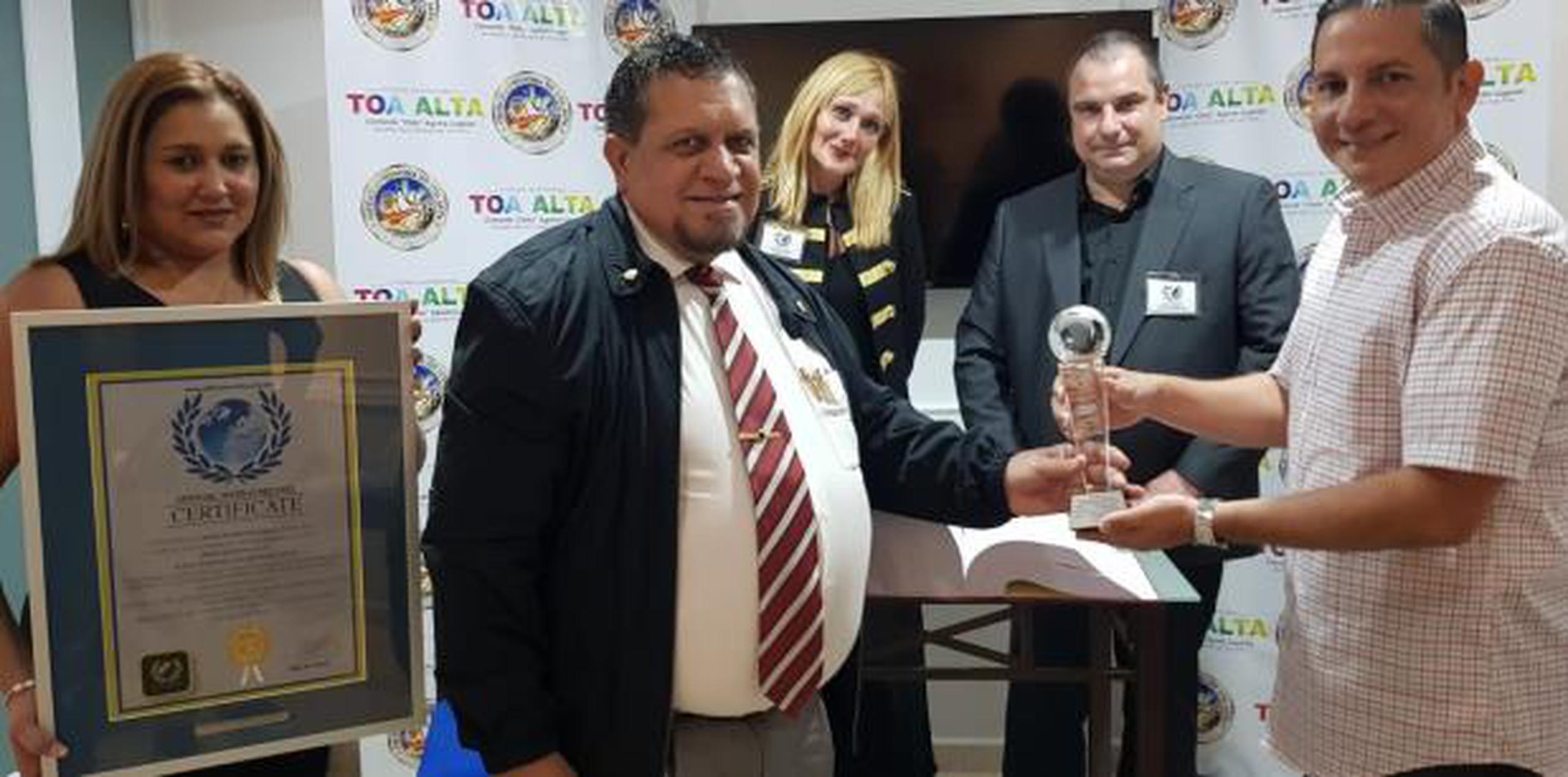 Morales (centro) recibió el premio de manos del alcalde de Toa Alta, Clemente Agosto. (Suministrada)
