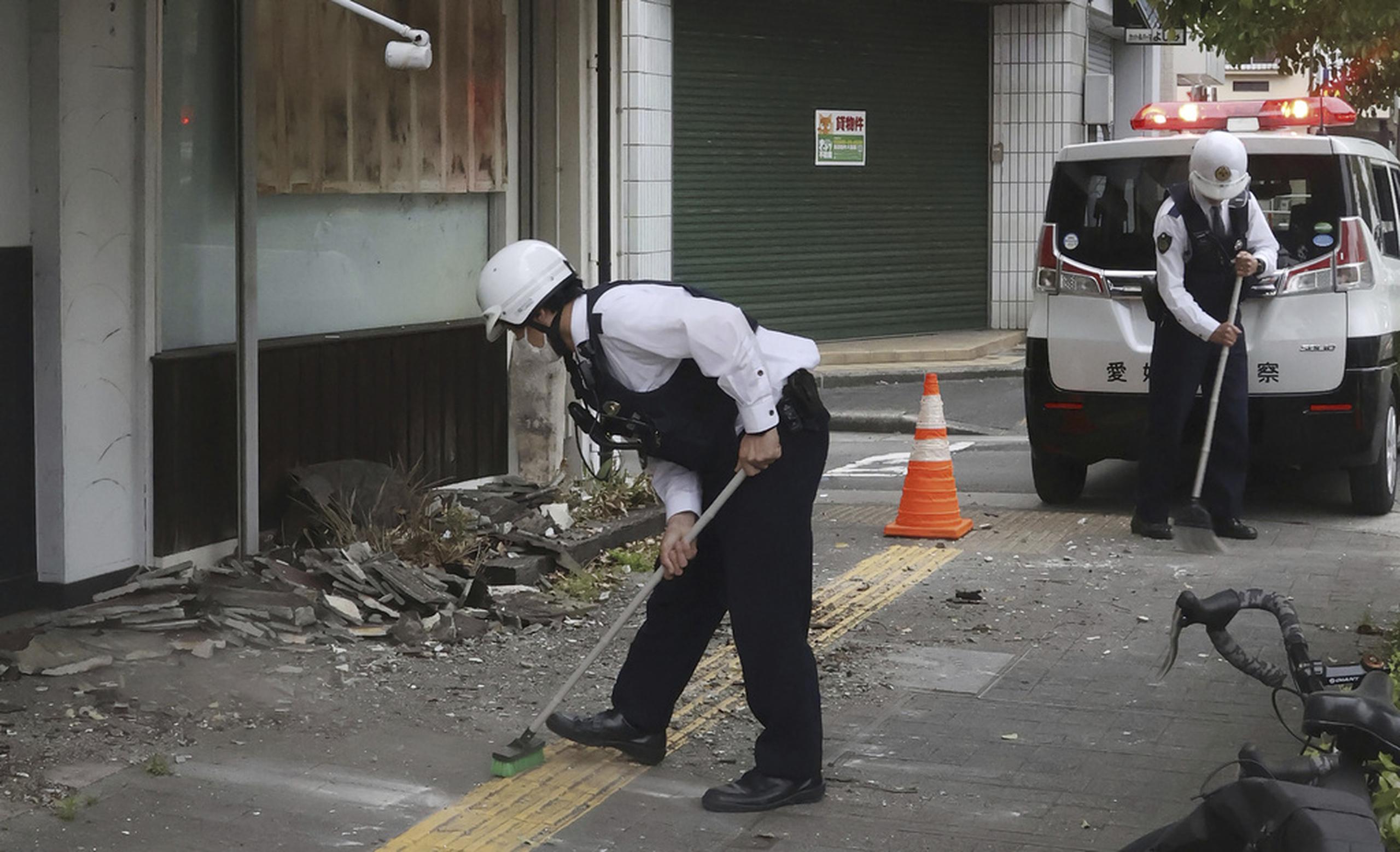 Policías despejan los escombros de un sismo en Uwajima, prefectura de Ehime, en el oeste de Japón, el 18 de abril de 2024.