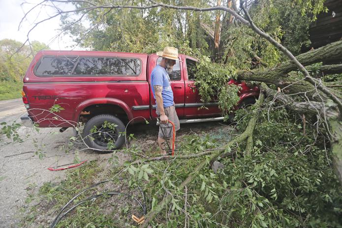 Adam Turley examina los daños sufridos por la camioneta de su padre delante de su casa en Concord Center Drive, en Concord, Wisconsin.