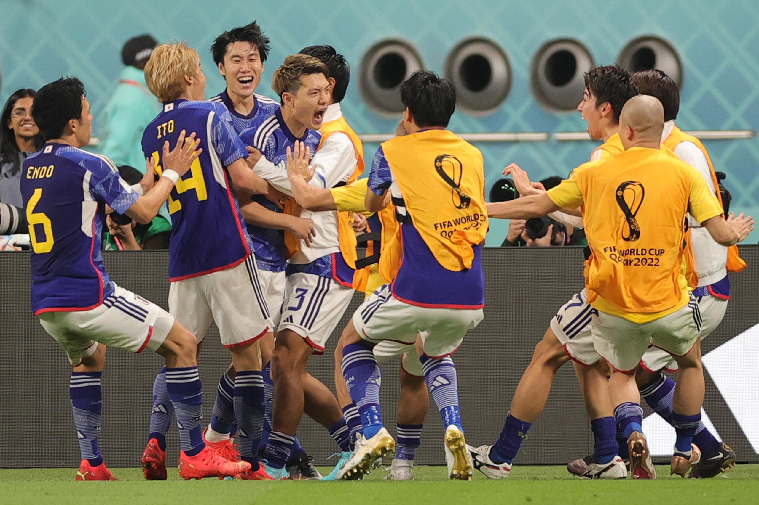 Jugadores de Japón rodean a Ritsu Doan luego de anotar el primero de dos goles de su selección en el segundo tiempo para sorprender a Alemania.