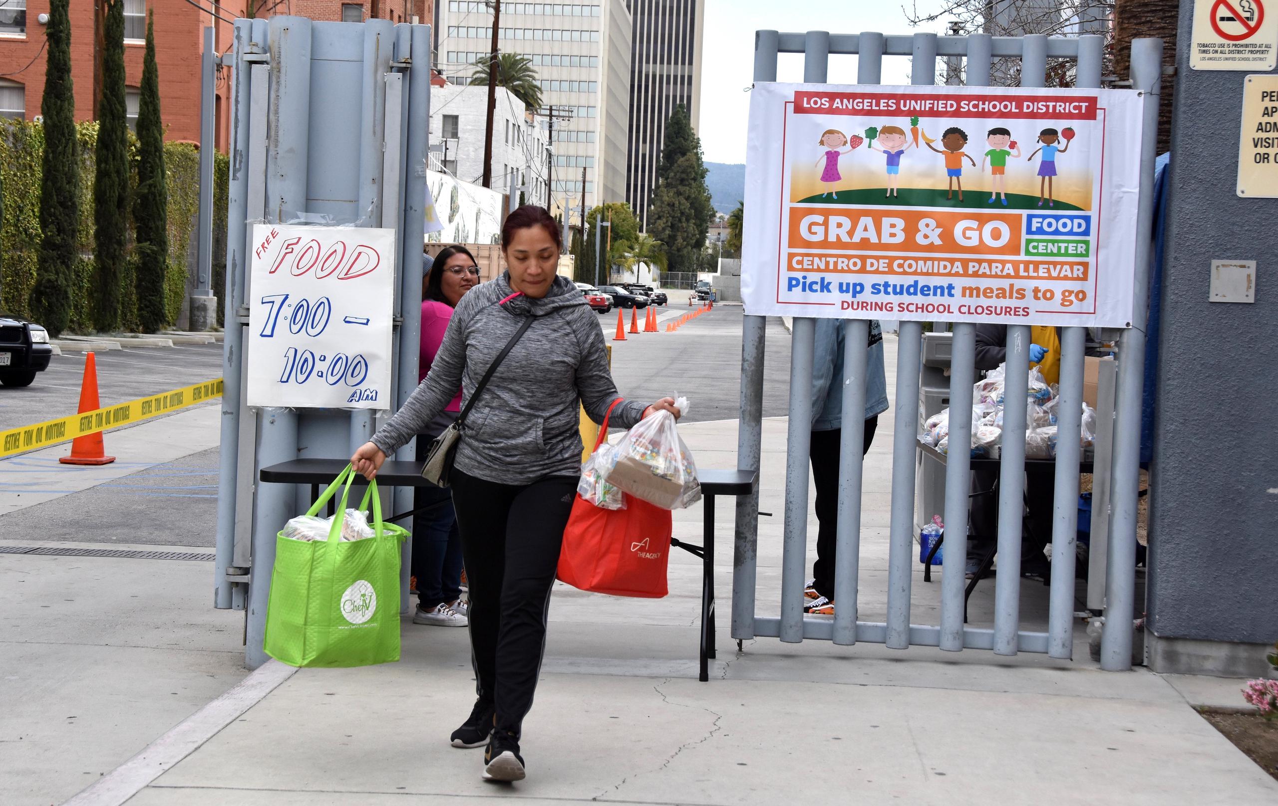 Cherry Morse lleva dos bolsas con las comidas de sus cuatro hijos y las de una amiga a su salida de la escuela Robert F. Kennedy en Los Ángeles, California