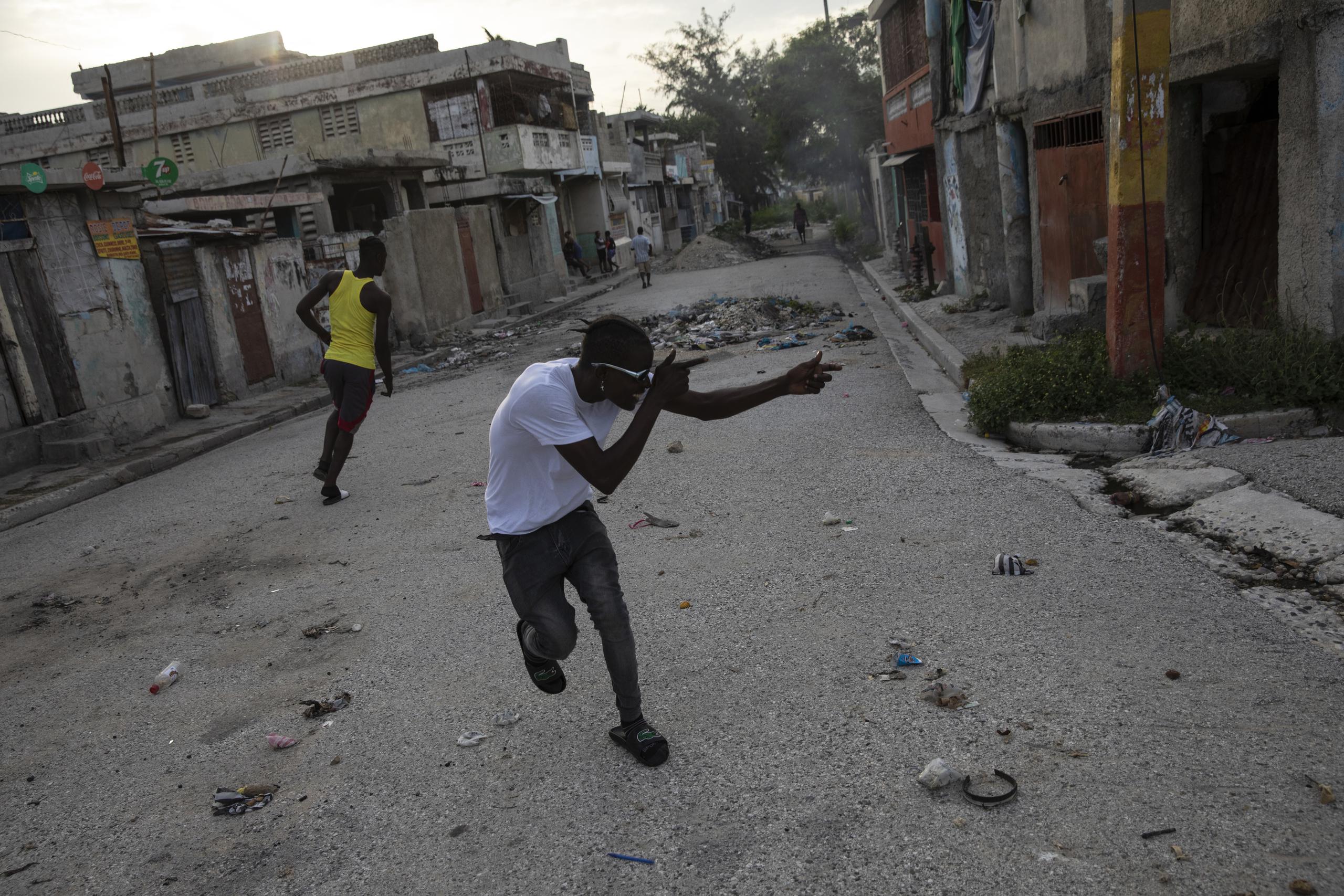 Miembro de una pandilla apunta con armas imaginarias a un rival de una ganga contraria en el barrio de Bel Air de Puerto Príncipe, uno de tantos controlados por pandilleros.