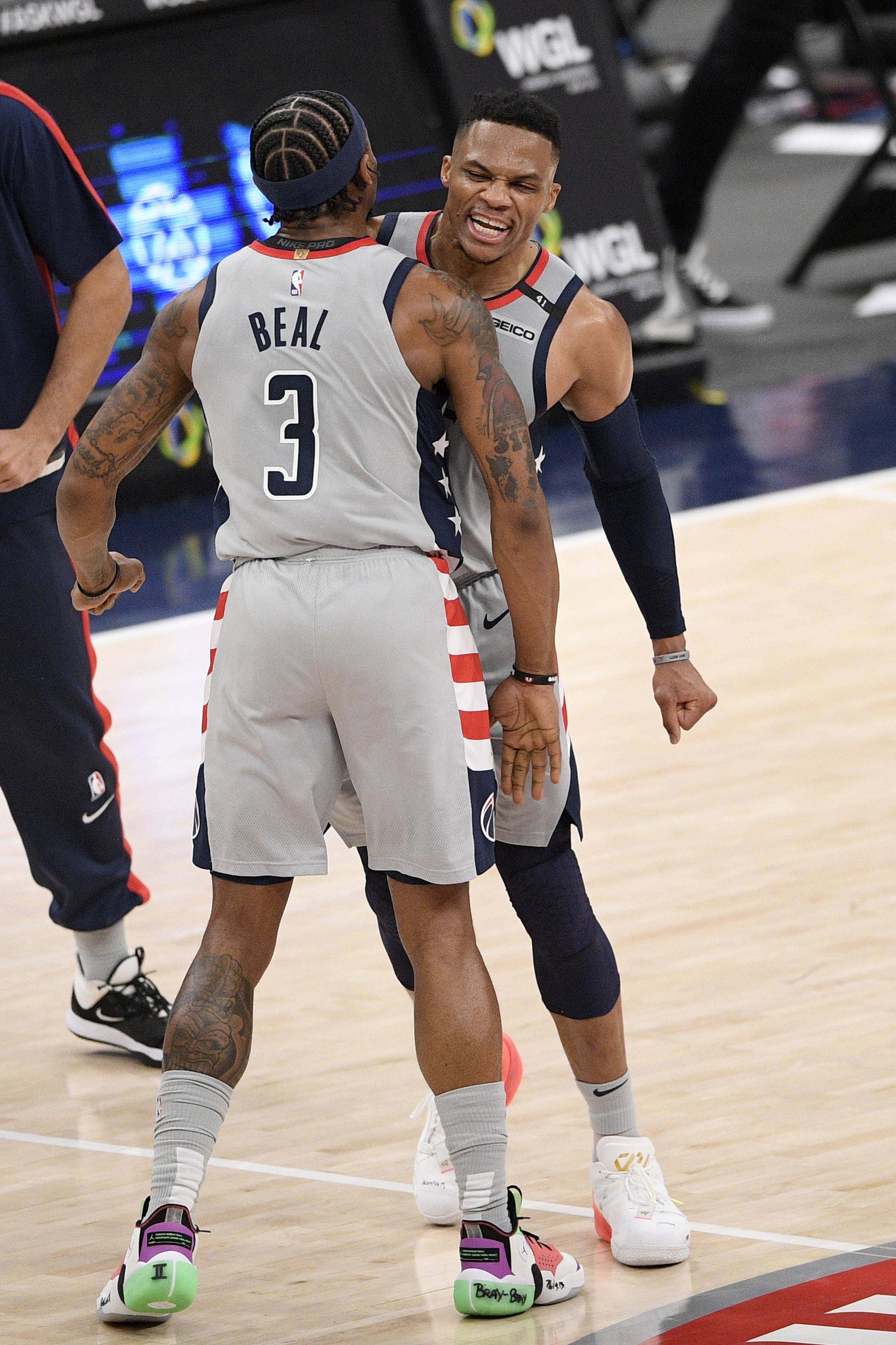 Bradley Beal, de los Wizards, celebra con su compañero Russell Westbrook luego de que Beal colara su importante triple en el encuentro de anoche ante los Nets.